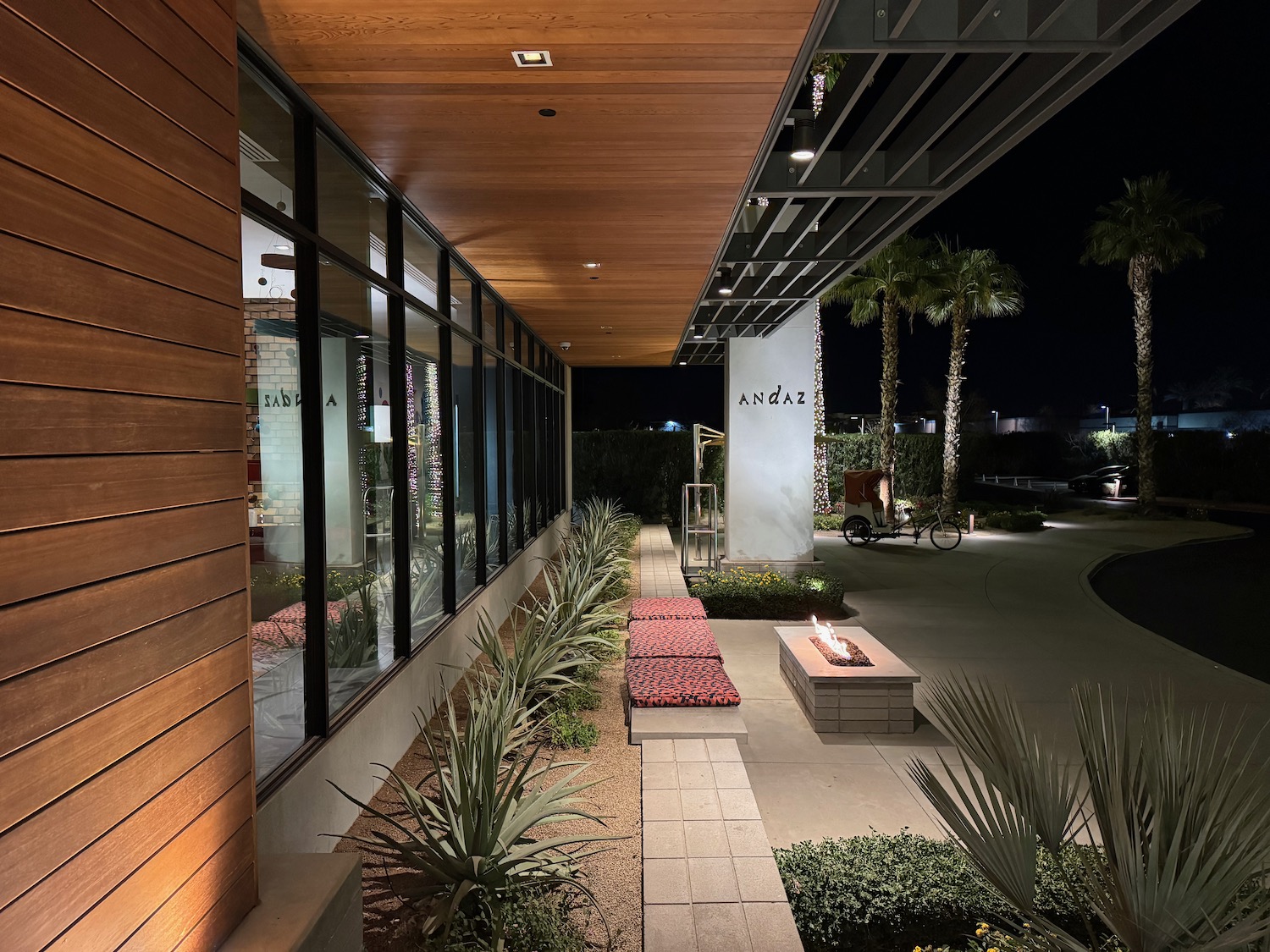 a building with a fire pit and palm trees