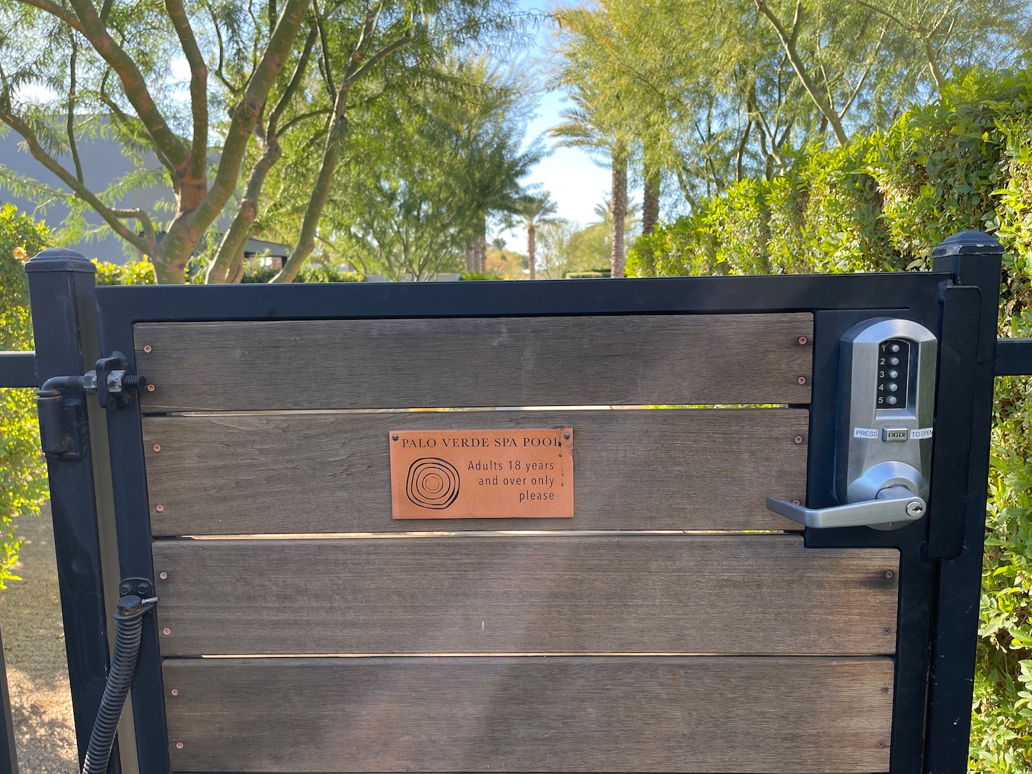 a wood gate with a metal door handle and a metal door handle