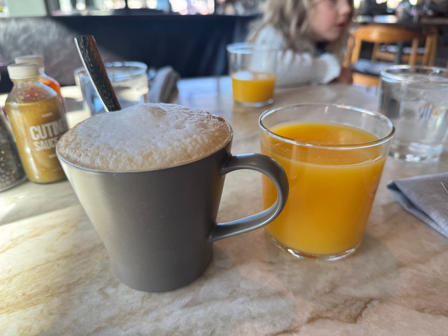 a mugs of coffee and orange juice on a table