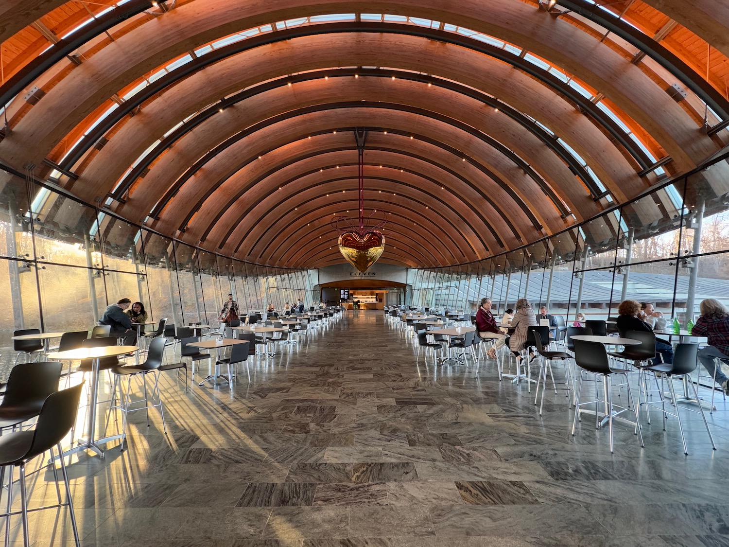 a room with tables and chairs with Crystal Bridges Museum of American Art in the background