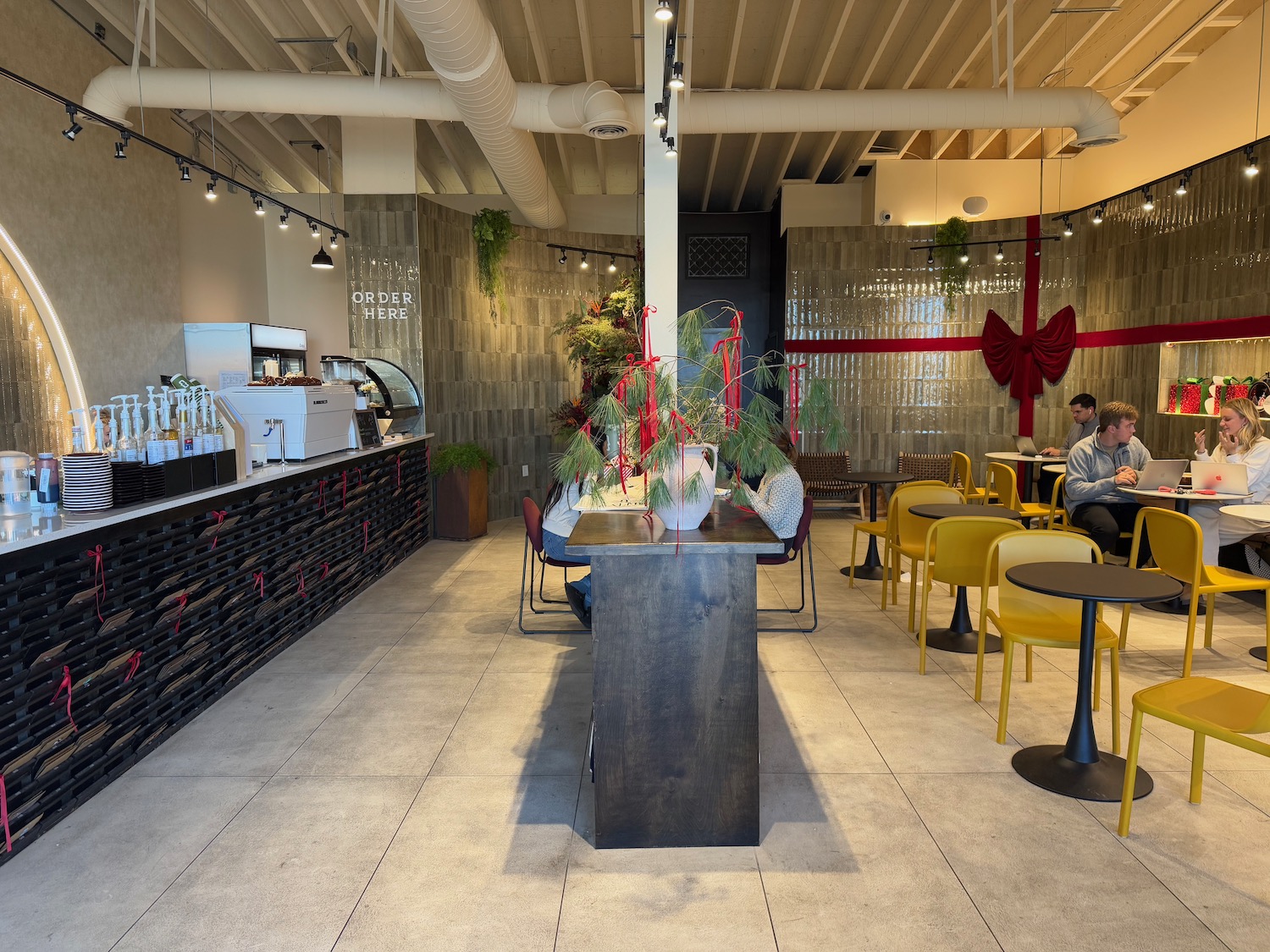 a room with tables and chairs and a table with plants