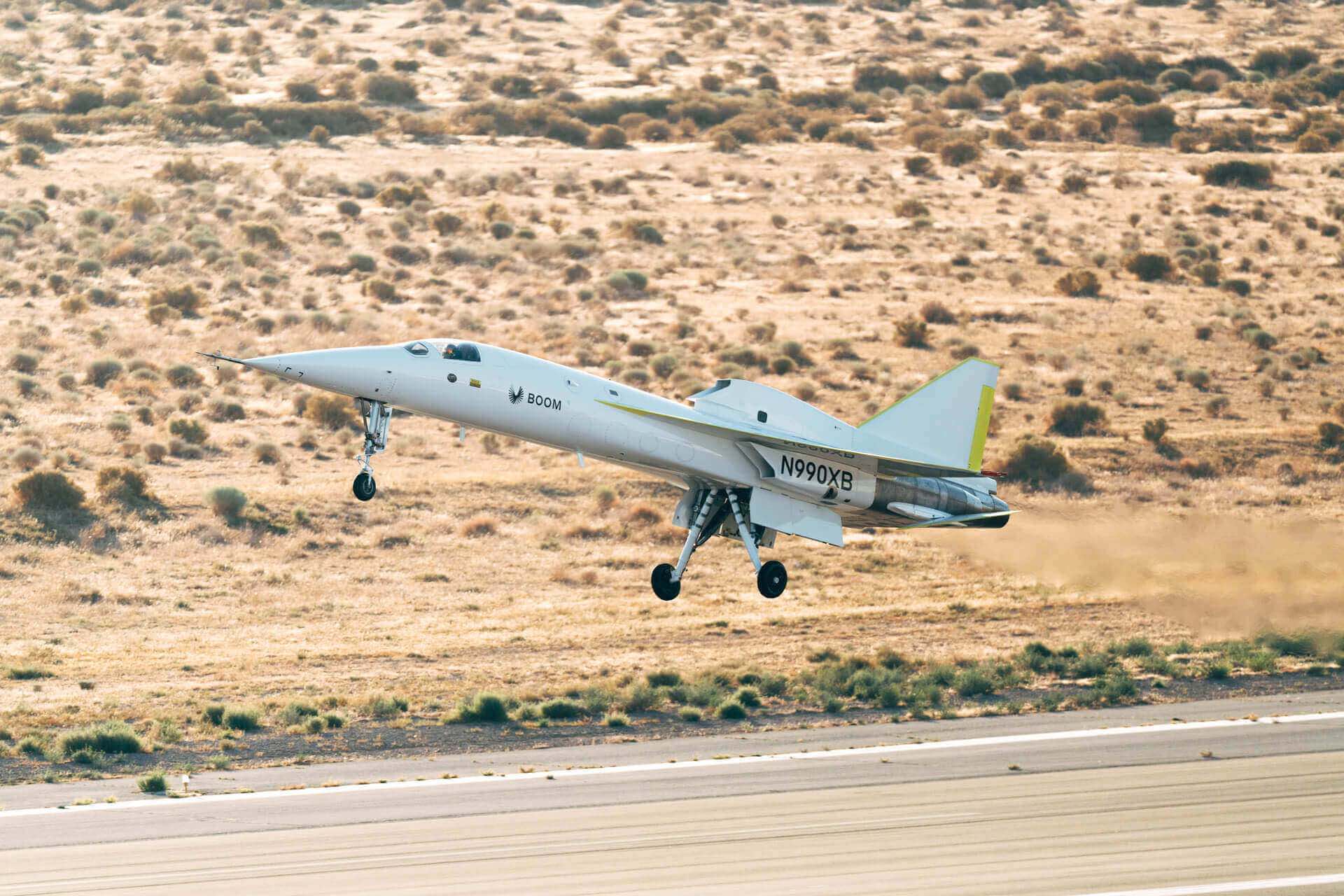 a jet plane flying over a field