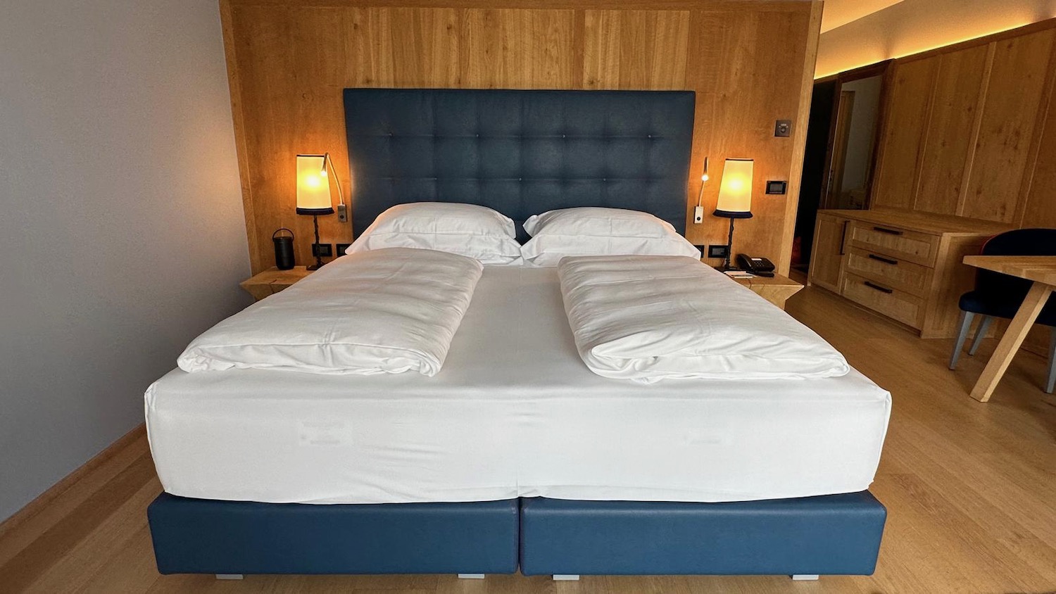 a bed with white sheets and pillows