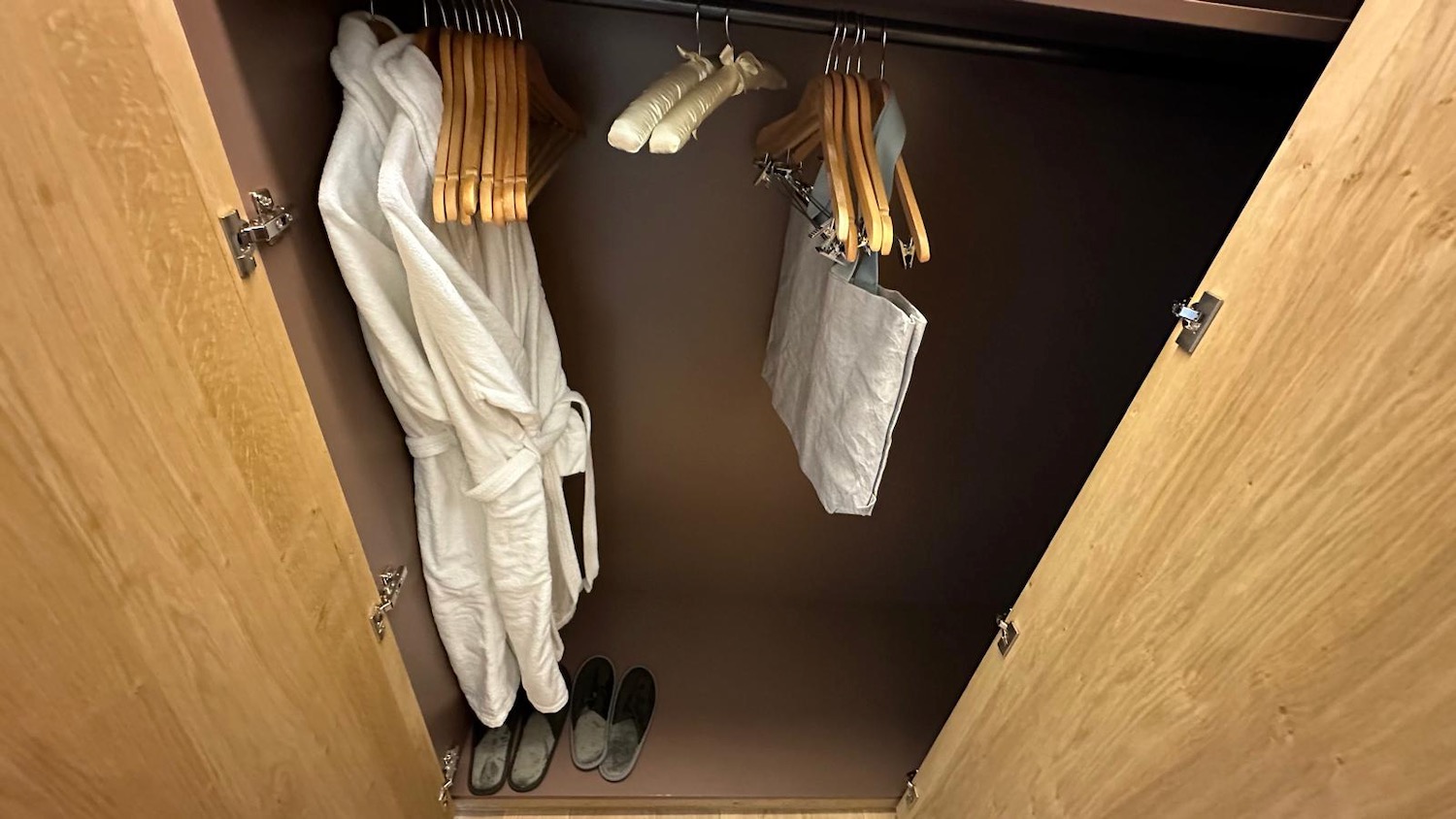 a closet with white robe and swingers