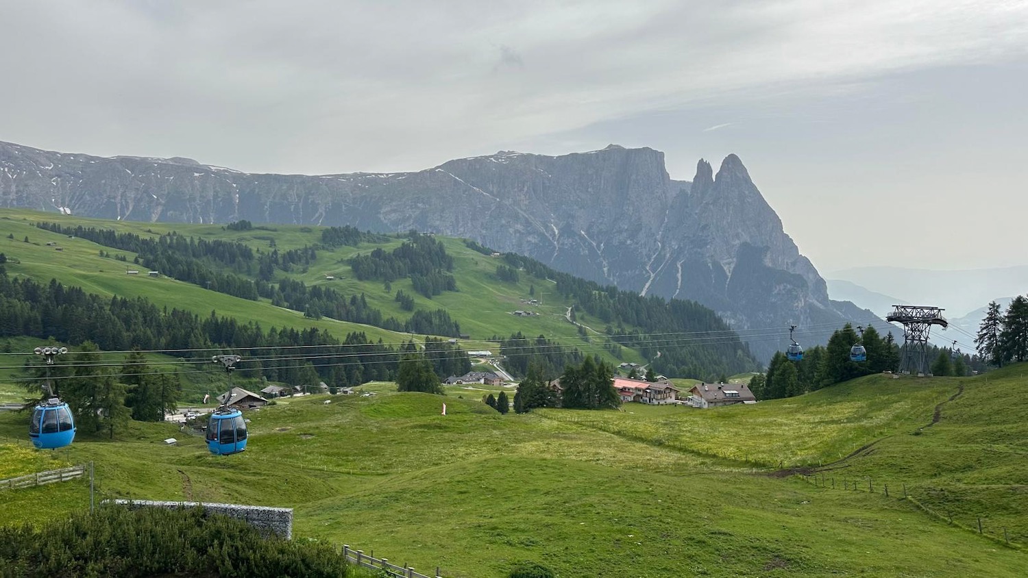 a cable car in a valley with mountains in the background