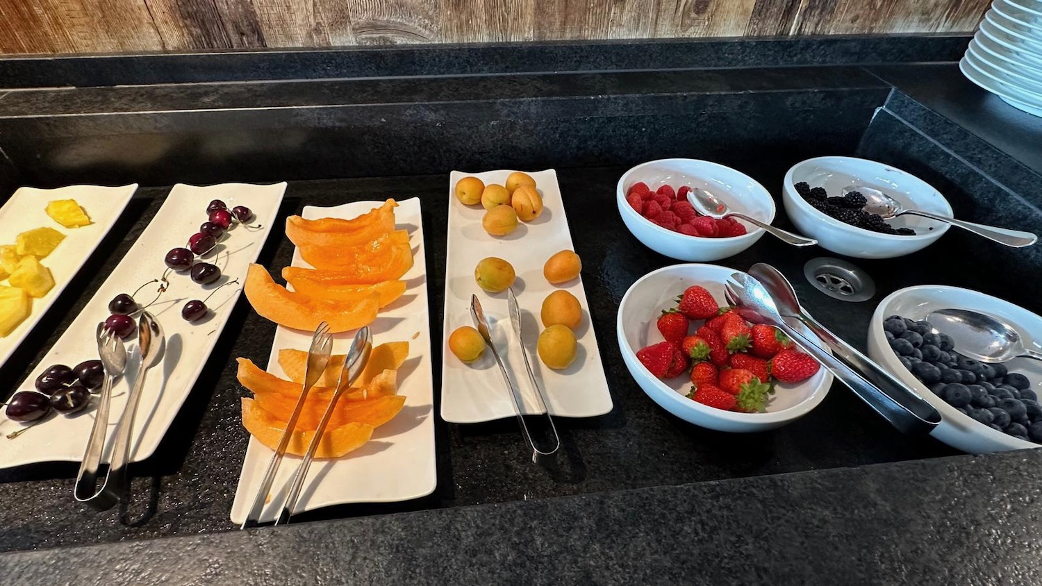 a table with plates of fruit and bowls of fruit