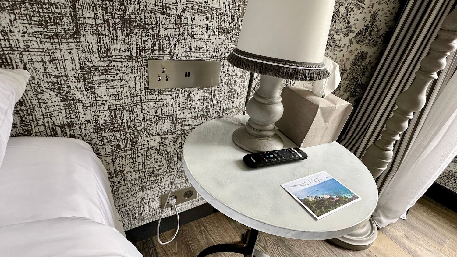 a table with a lamp and a remote on it