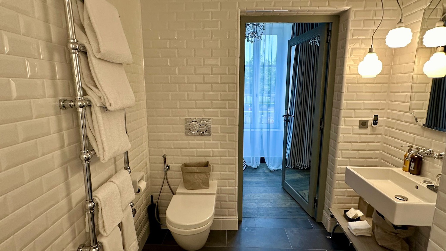 a bathroom with a toilet and towels on the wall