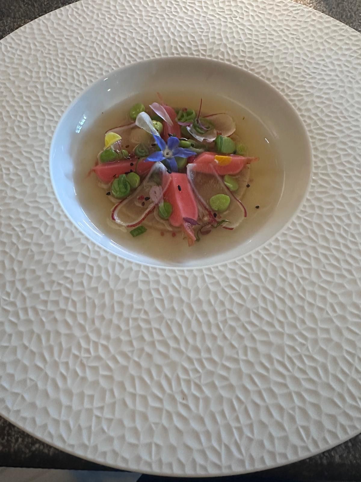 a bowl of soup with flowers in it