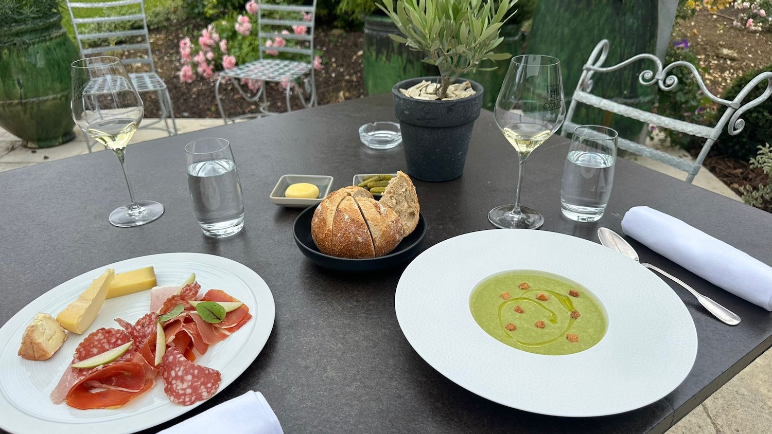 a table with plates of food and glasses of wine