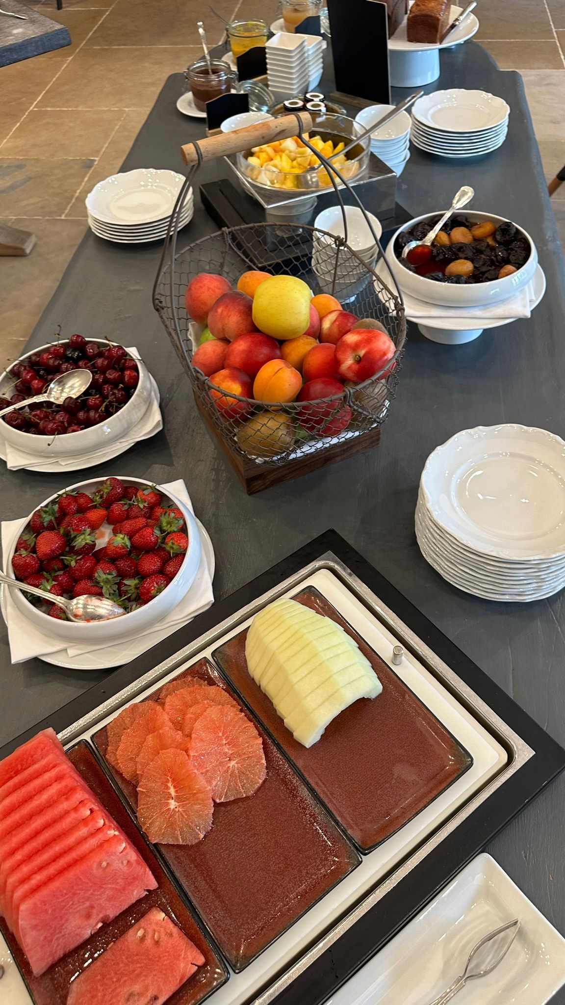 a table with plates of fruit and a bowl of fruit