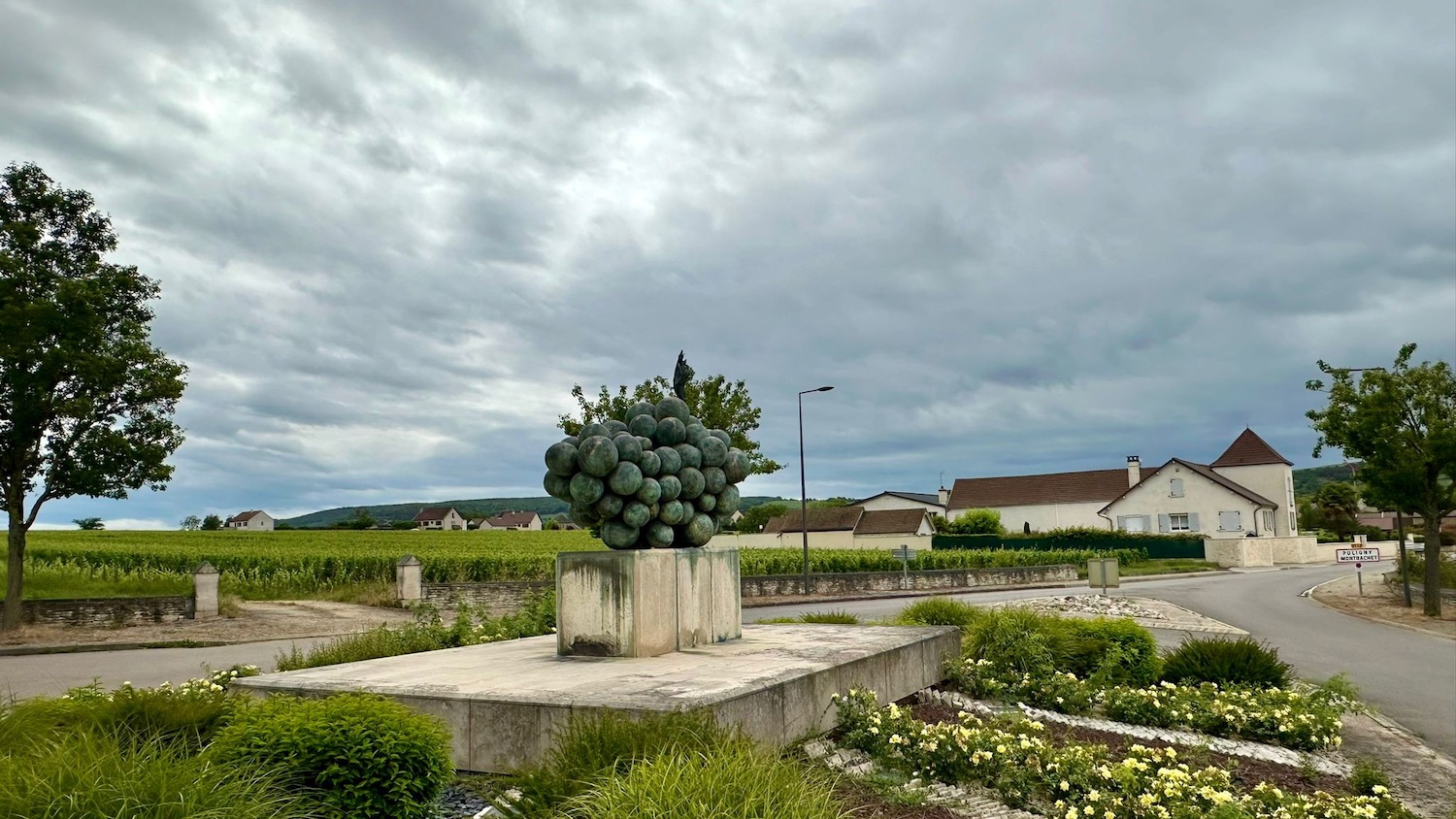 a large statue of grapes in a field