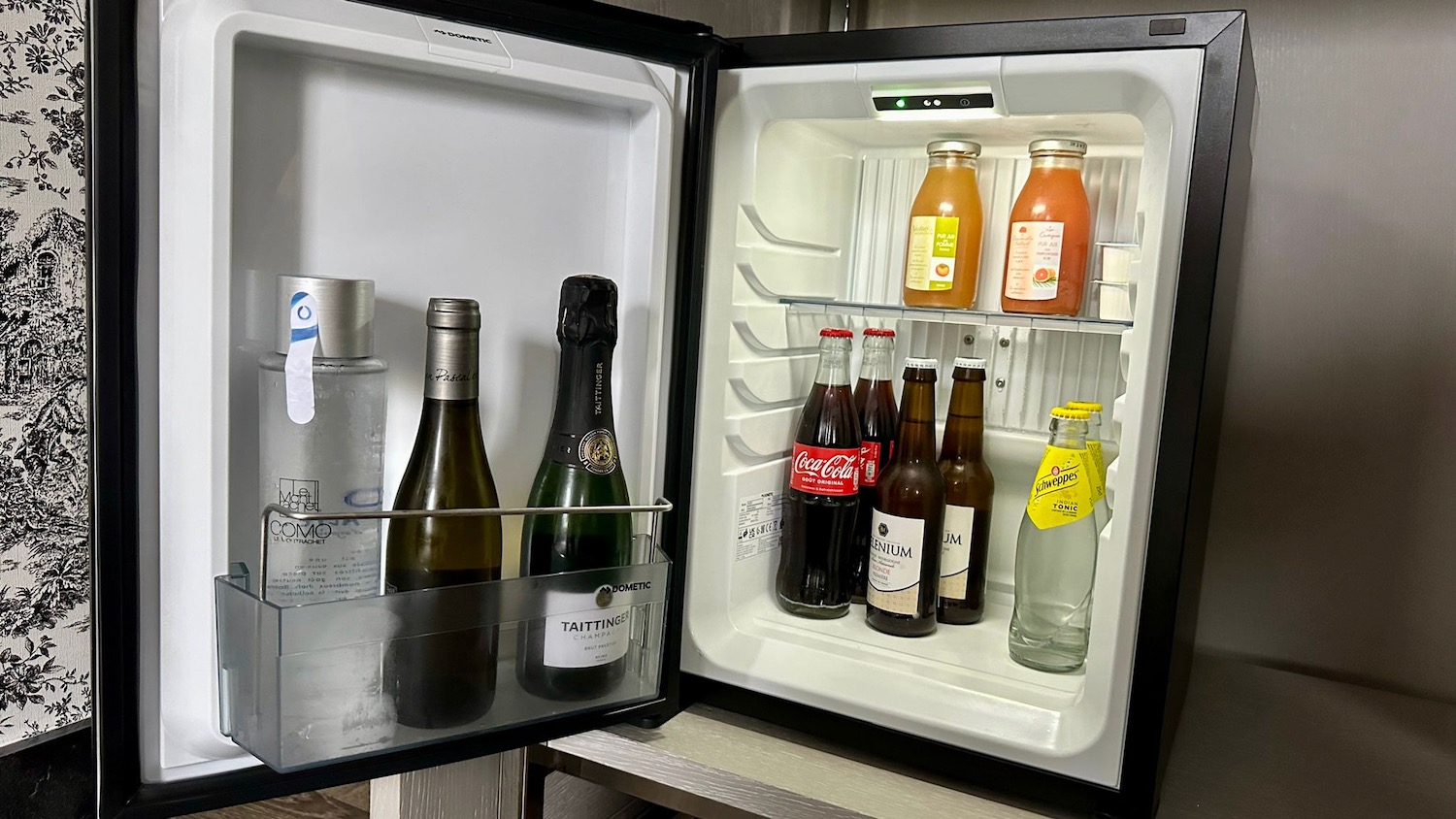 a mini fridge with bottles of alcohol inside