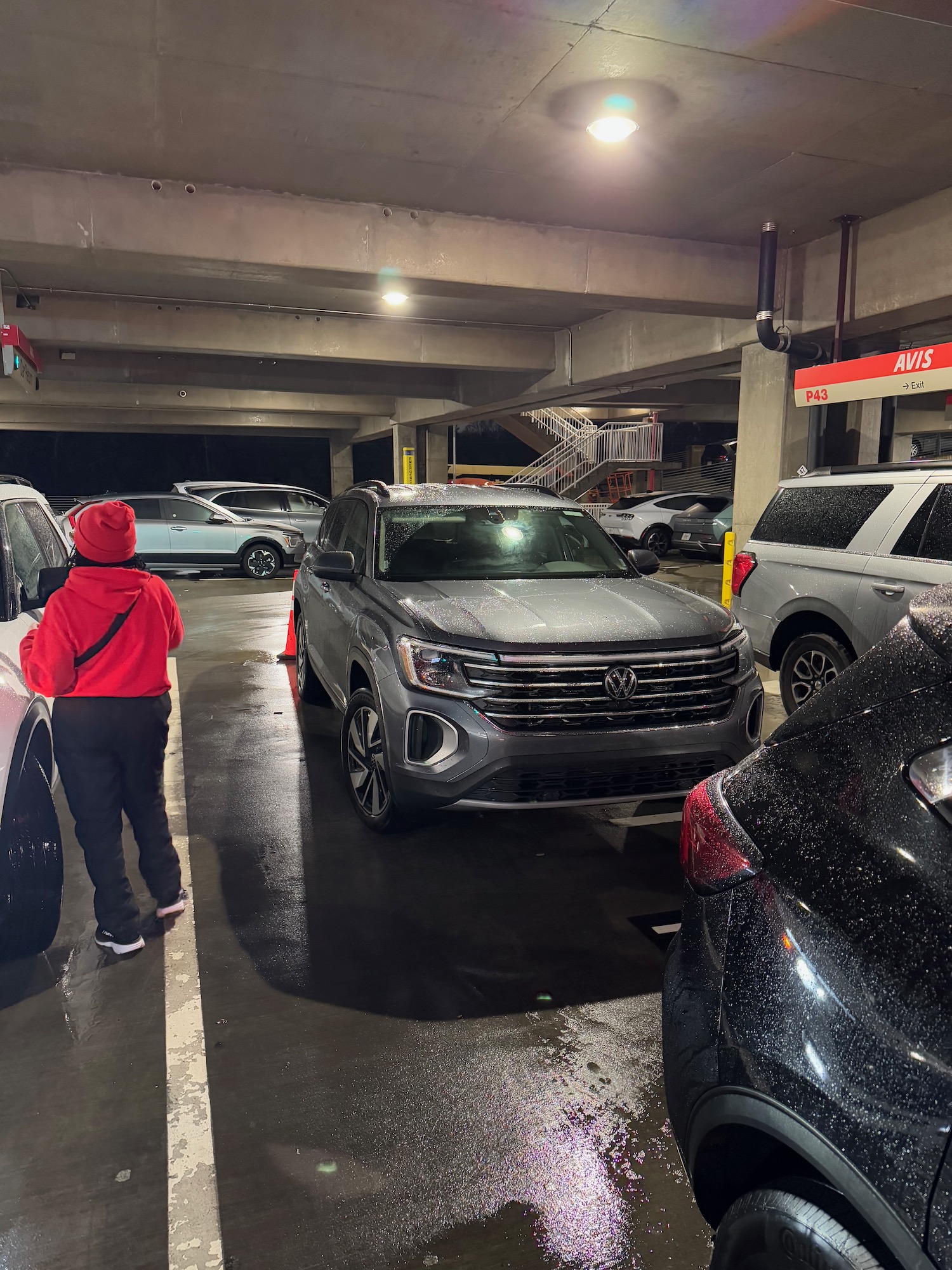 a person standing in a parking garage with cars