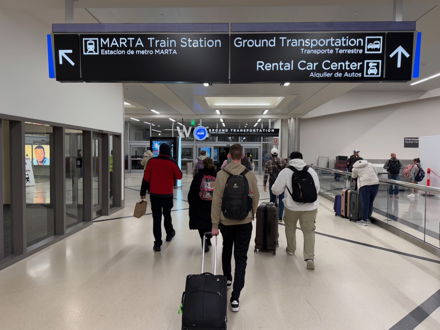 a group of people walking with luggage in a building