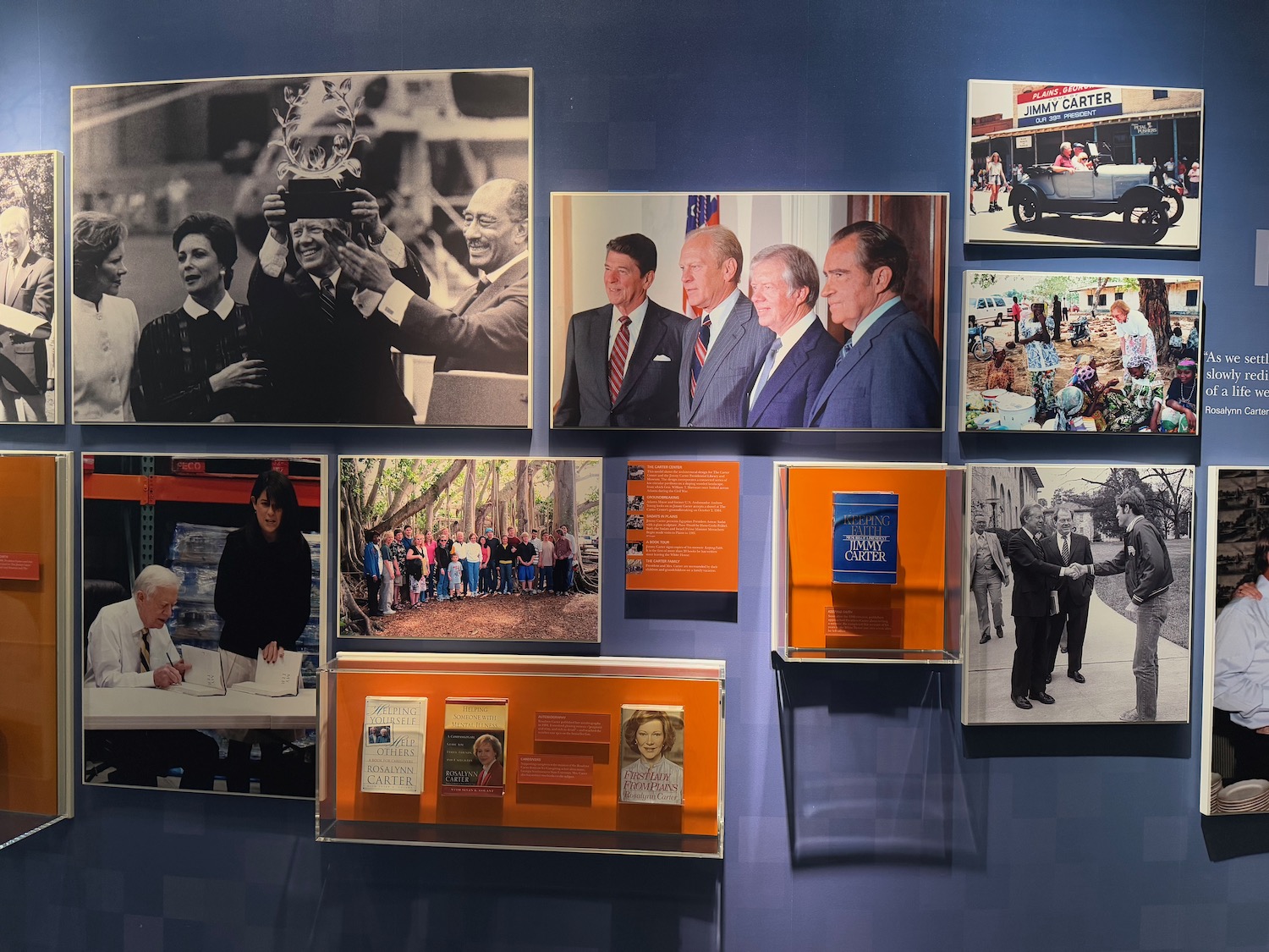 a wall with pictures of people and a book