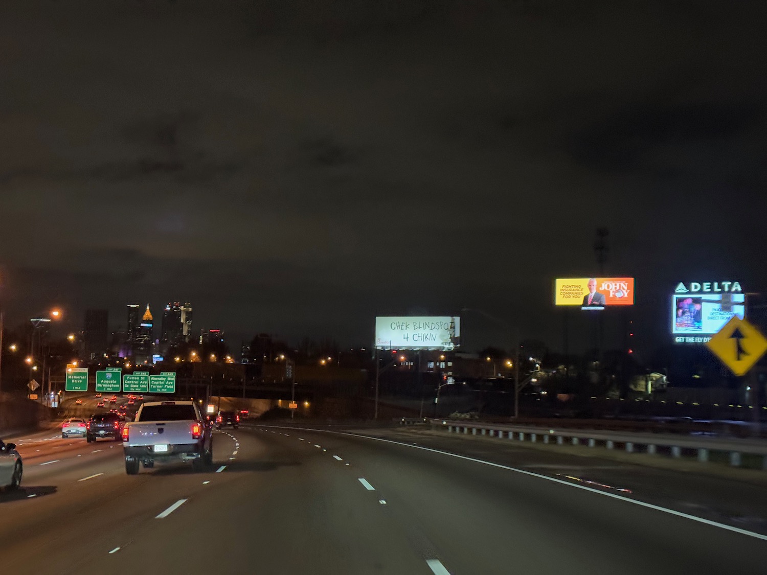 a road with cars and billboards at night