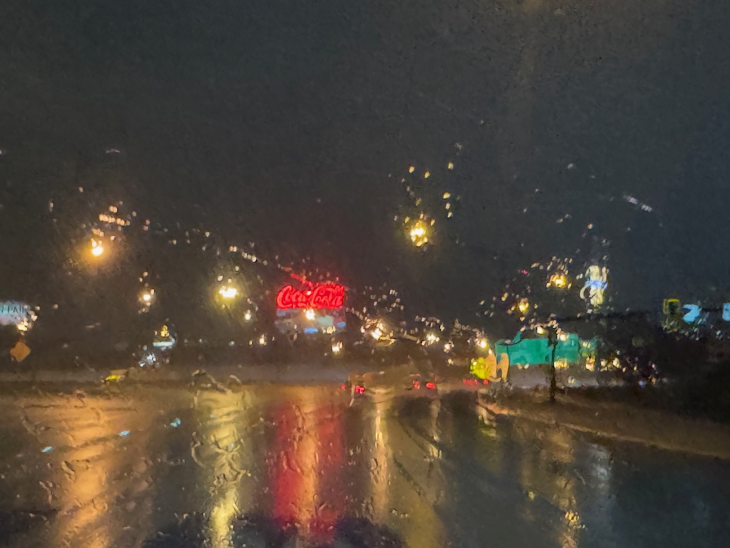 a wet road with a sign on it