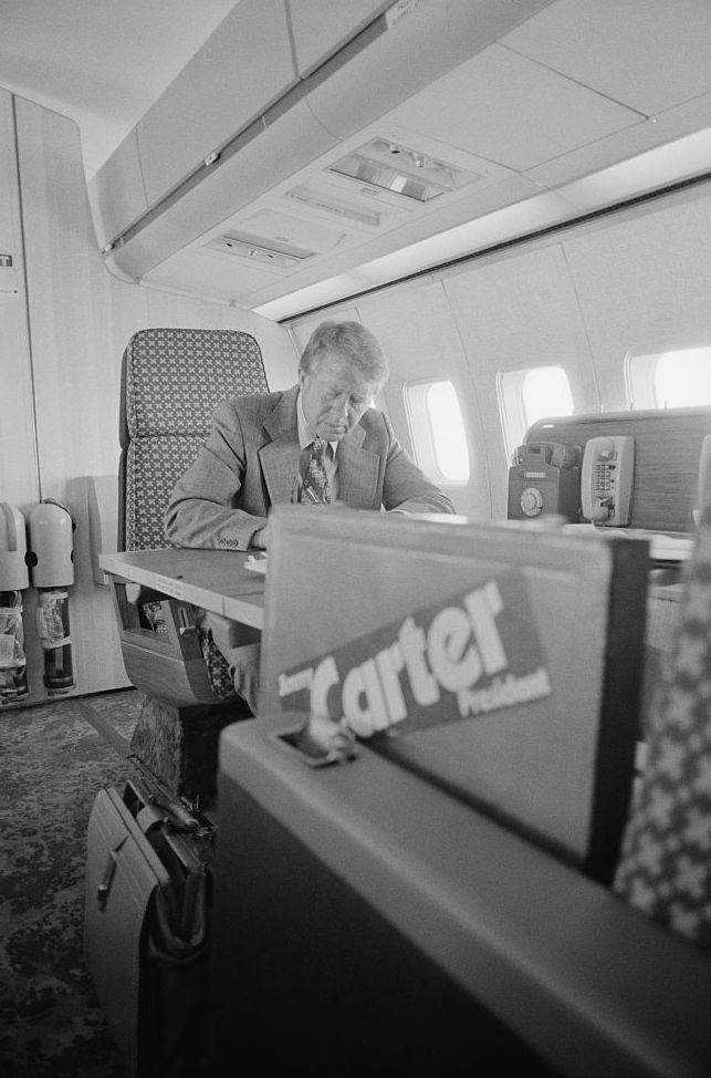 a man sitting at a desk in an airplane