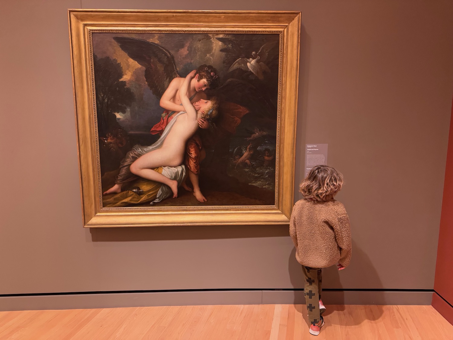 a child looking at a painting on a wall