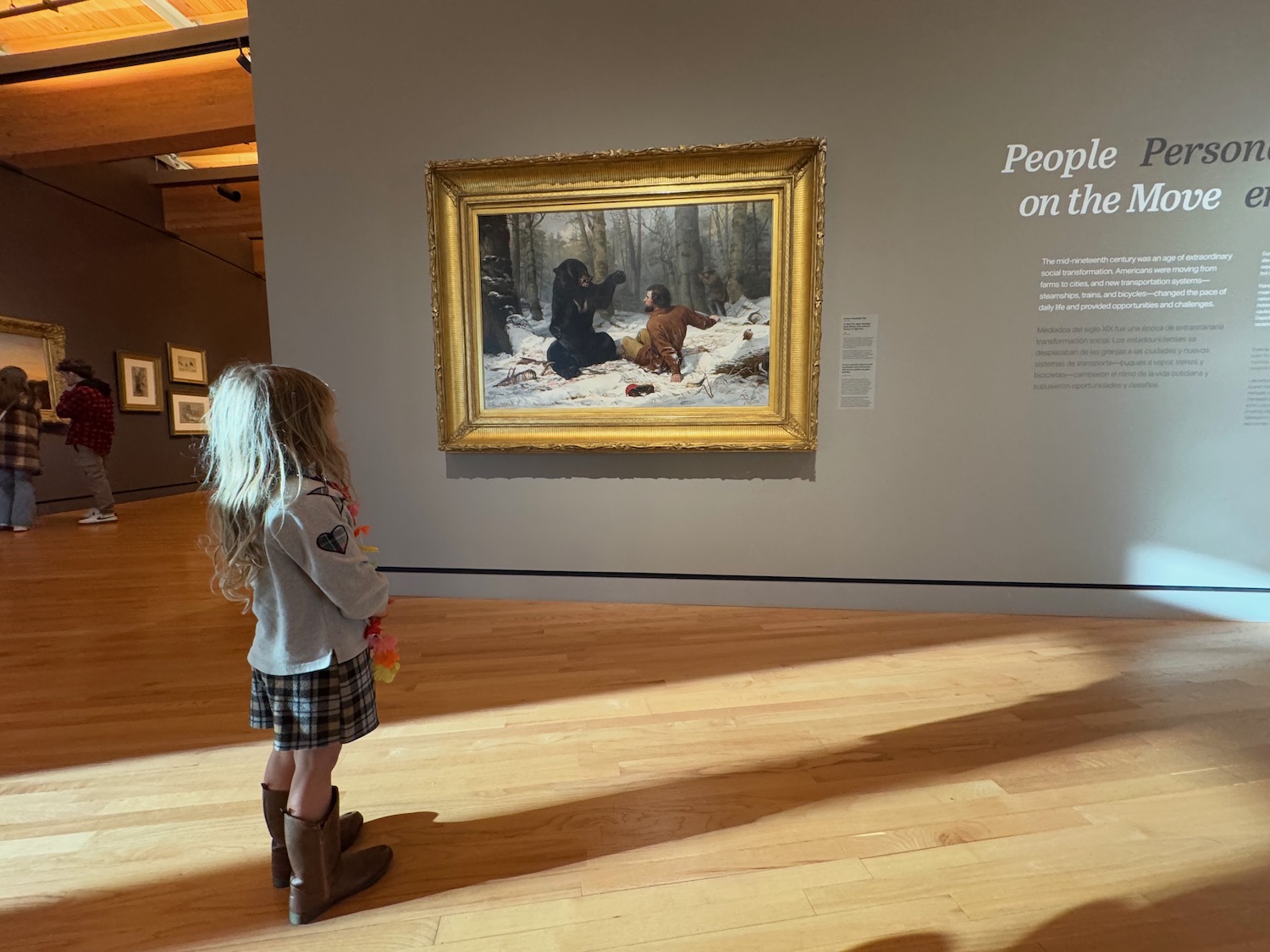 a girl looking at a painting on a wall