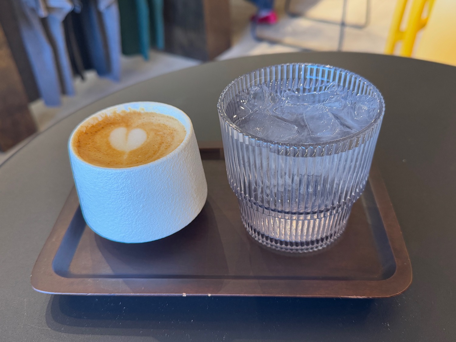 a cup of coffee and a glass of water on a tray