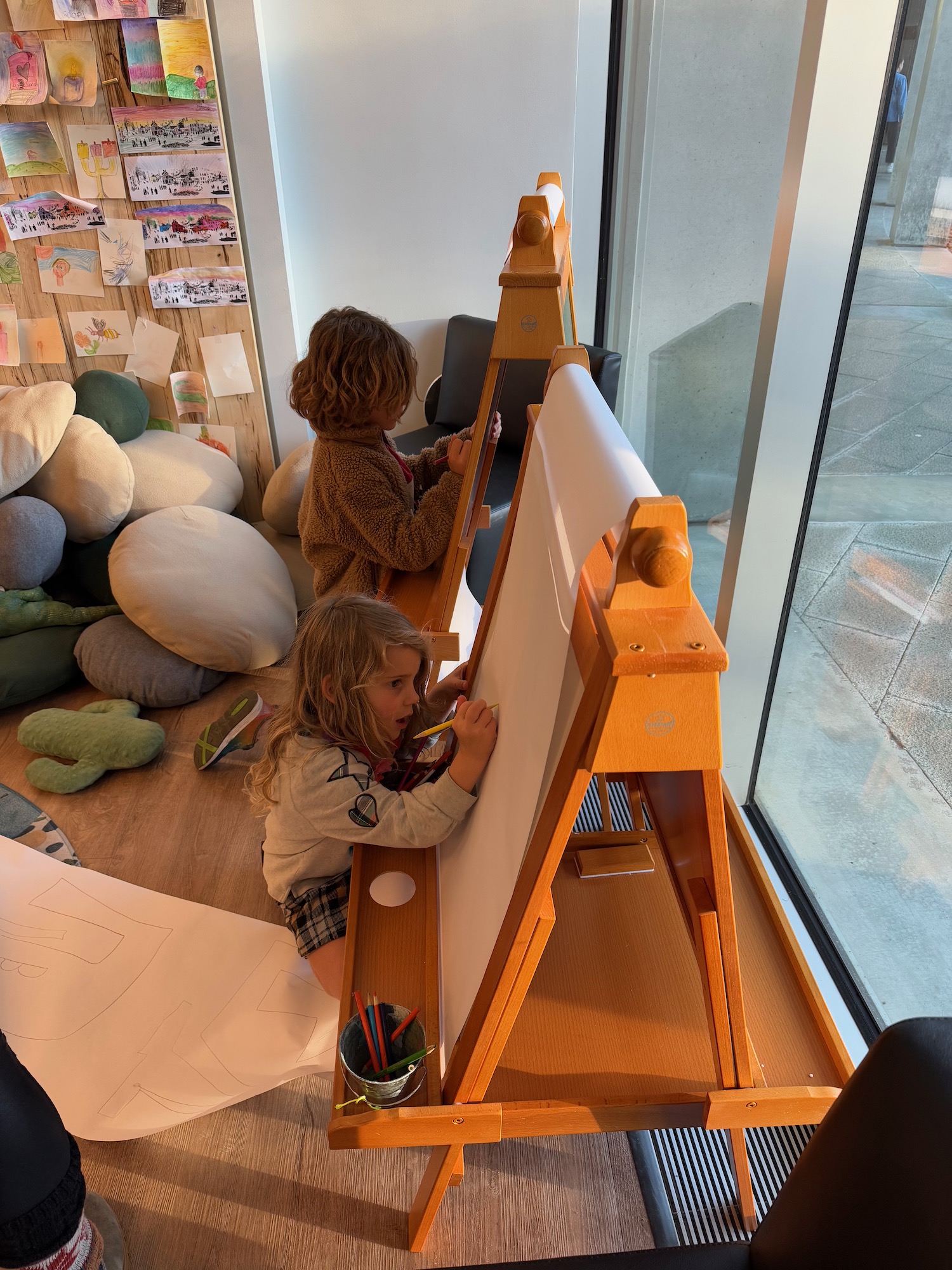 a two children drawing on a easel