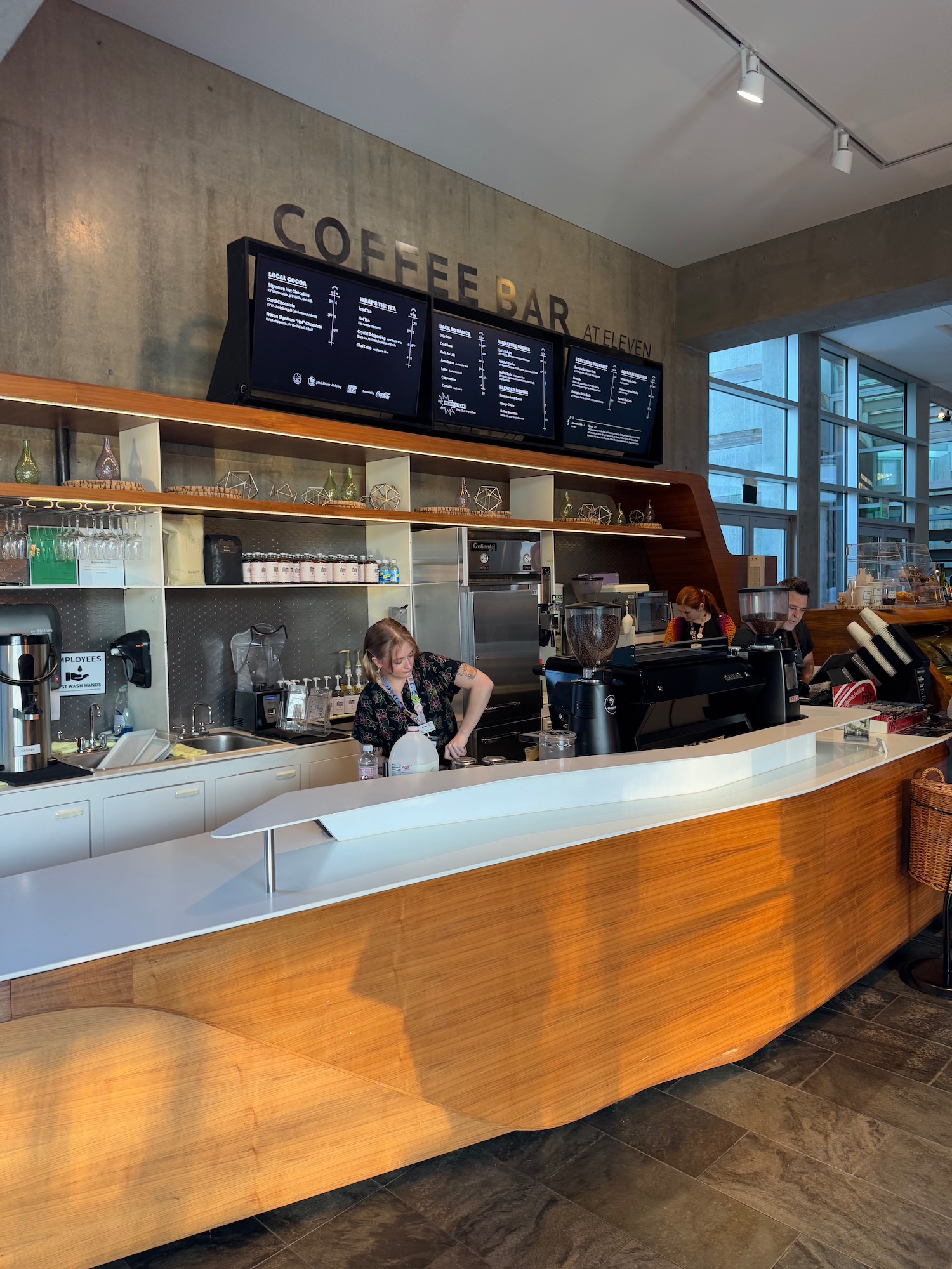 a woman behind a counter in a coffee shop