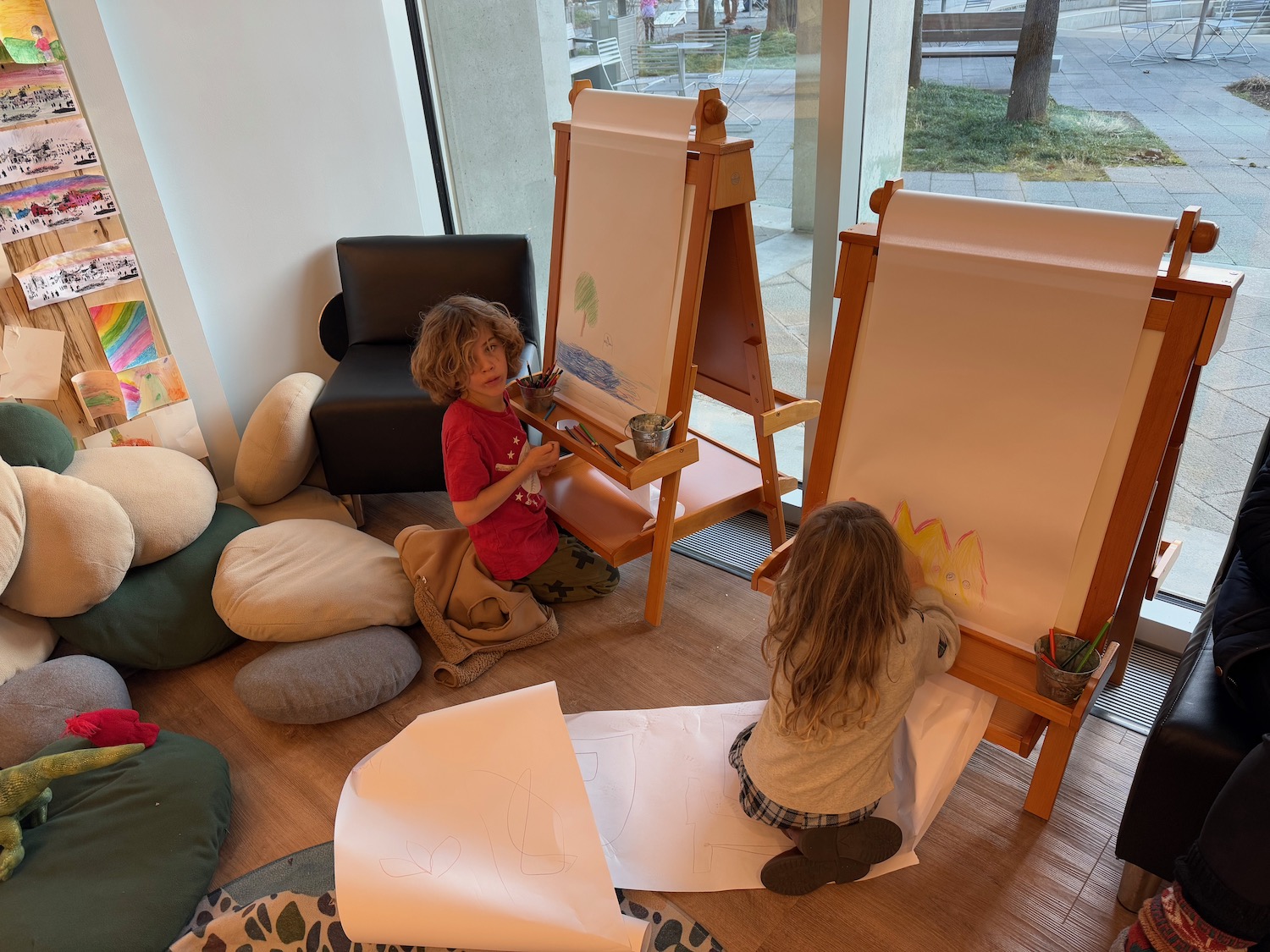 a two children drawing on a easel