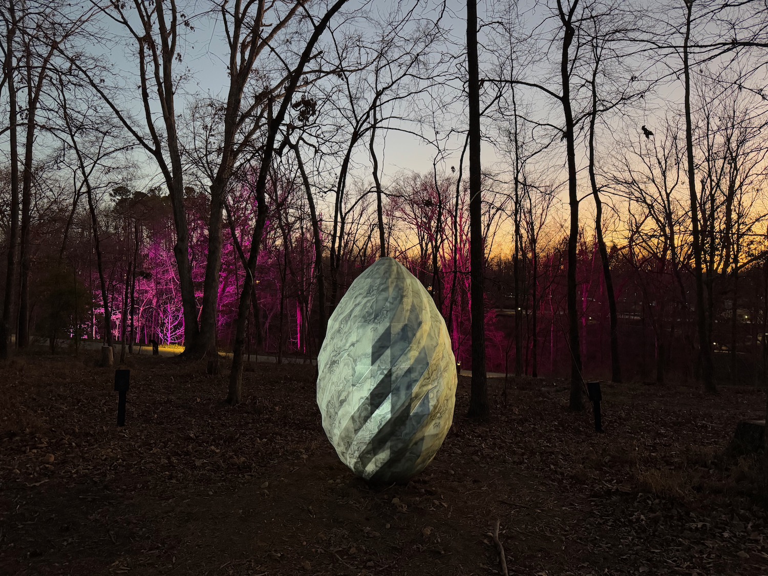 a large egg shaped sculpture in a forest