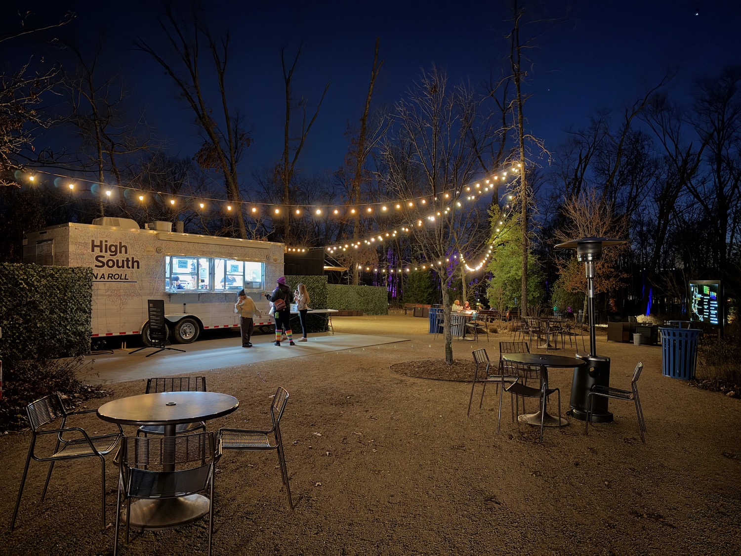 a food truck and tables and chairs in a park