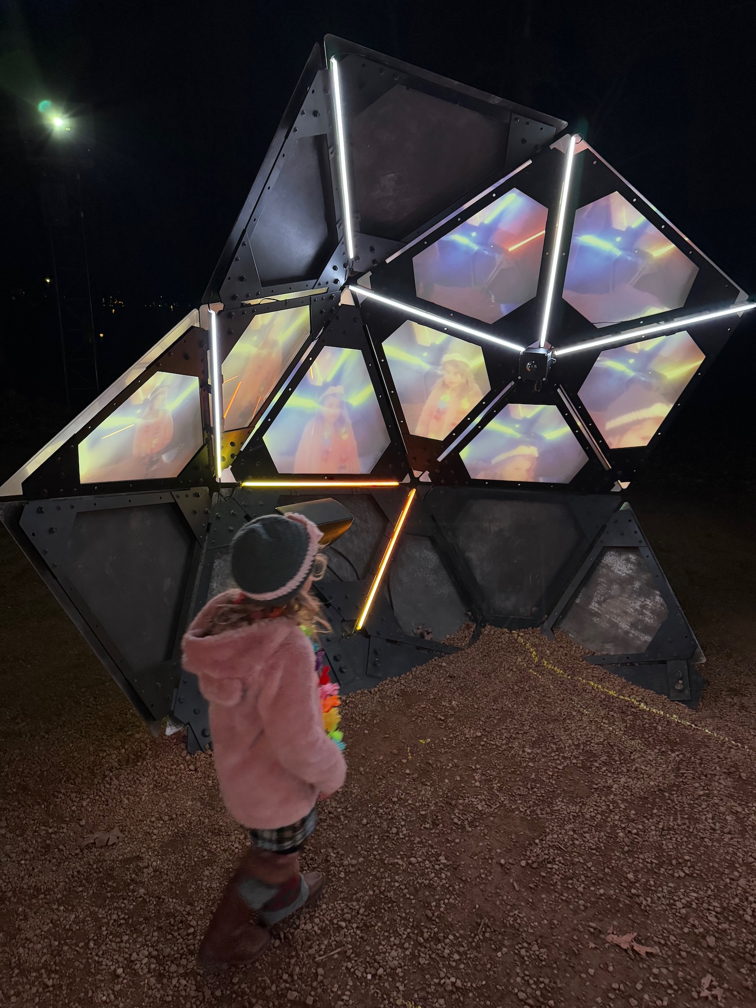 a girl standing in front of a large metal structure