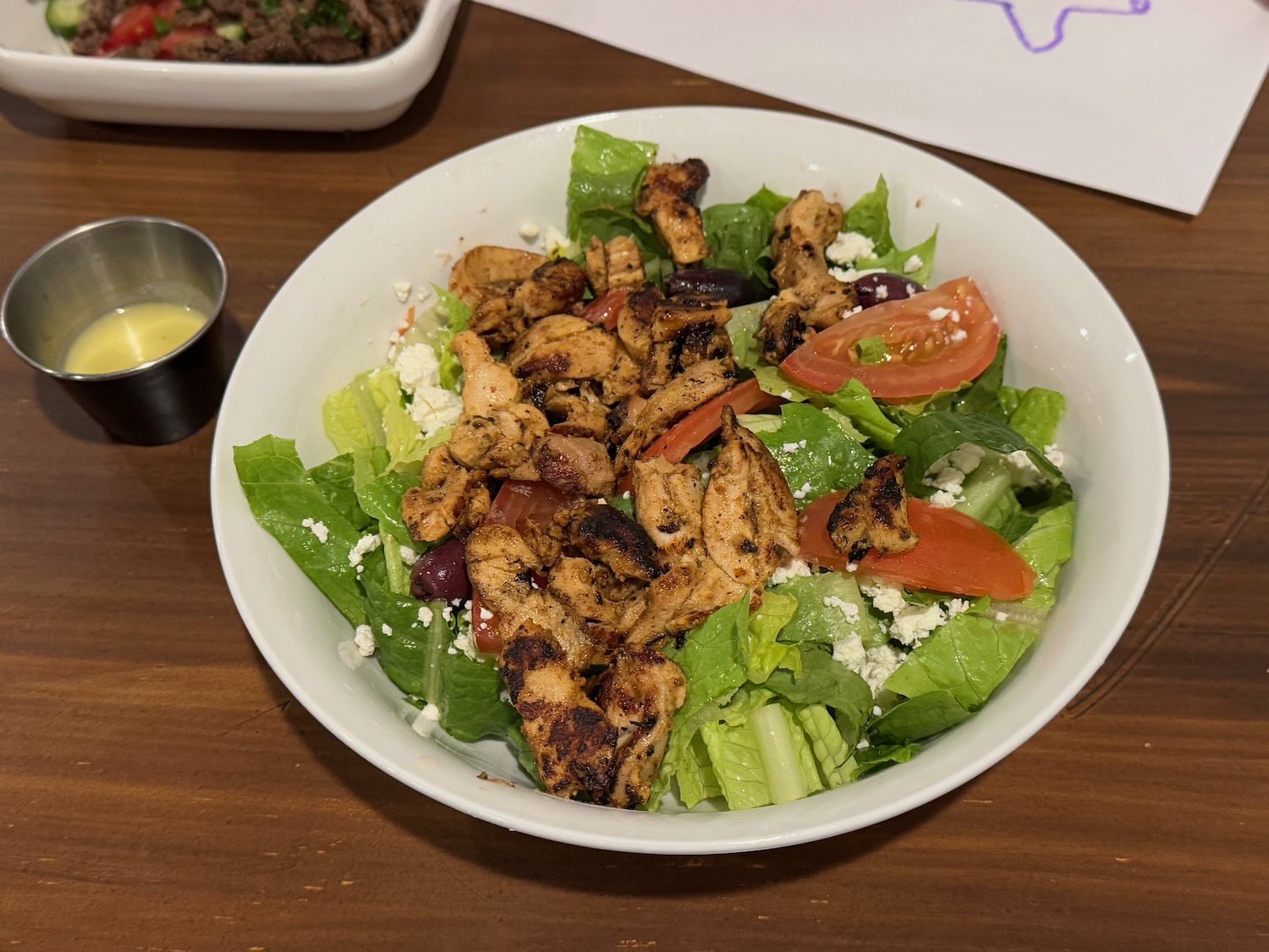 a bowl of salad with chicken and vegetables