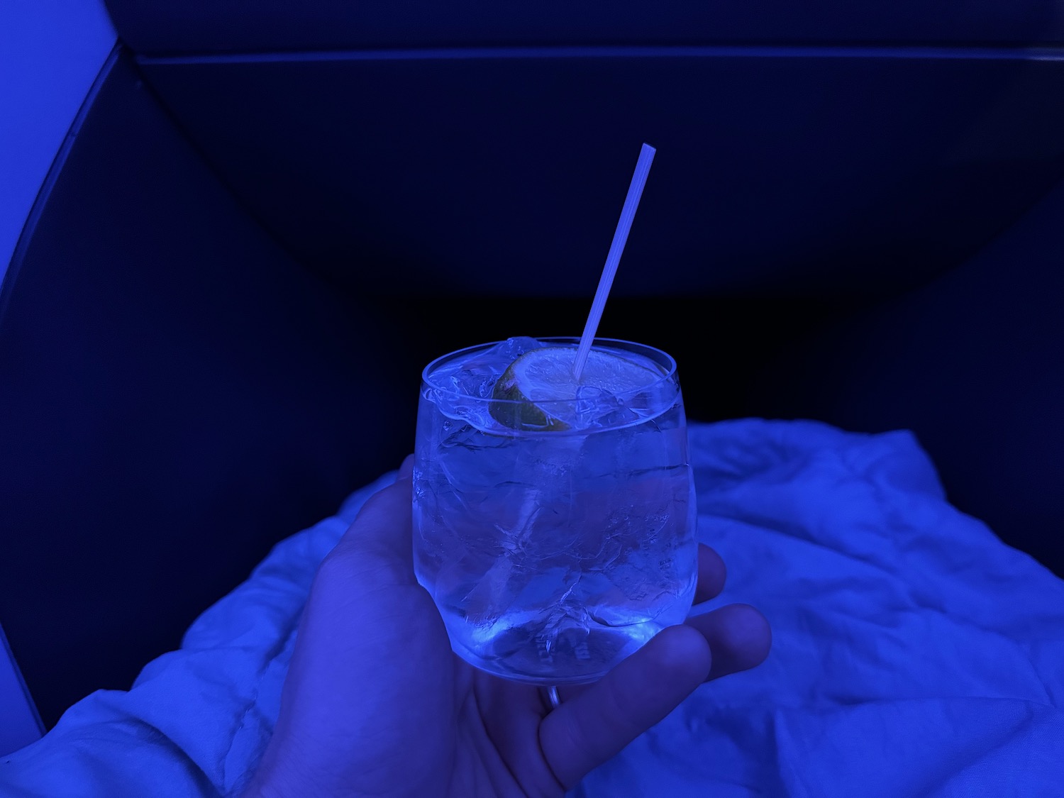 a hand holding a glass of water with a straw