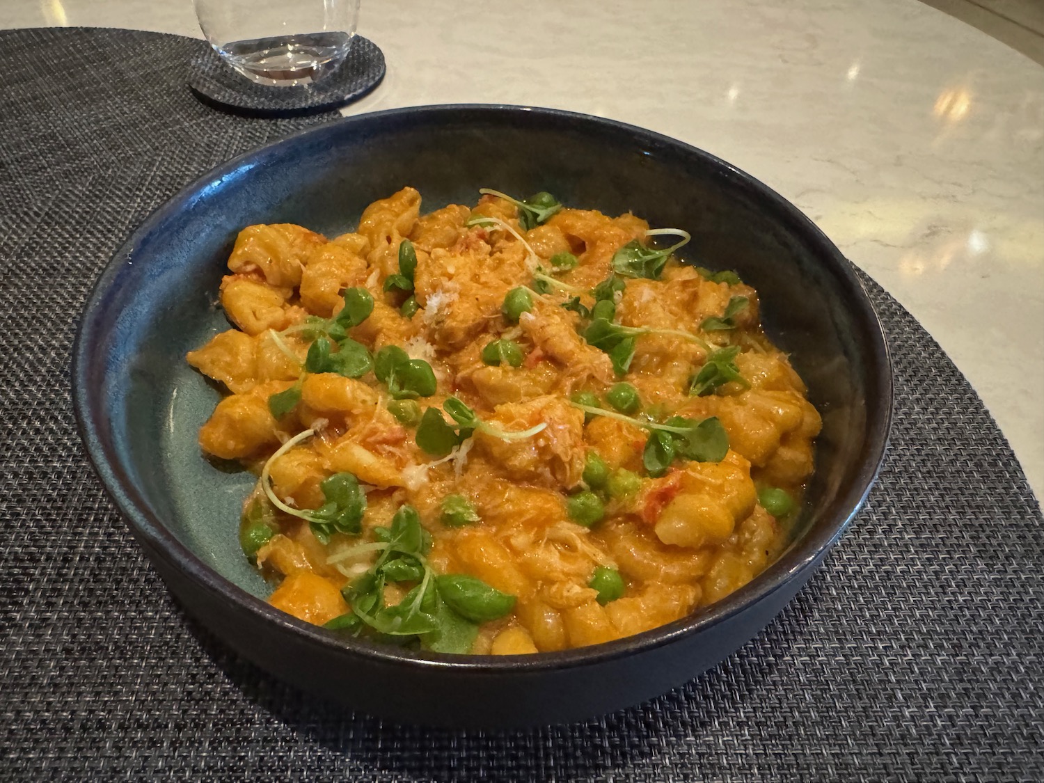 a bowl of pasta with green peas and cheese