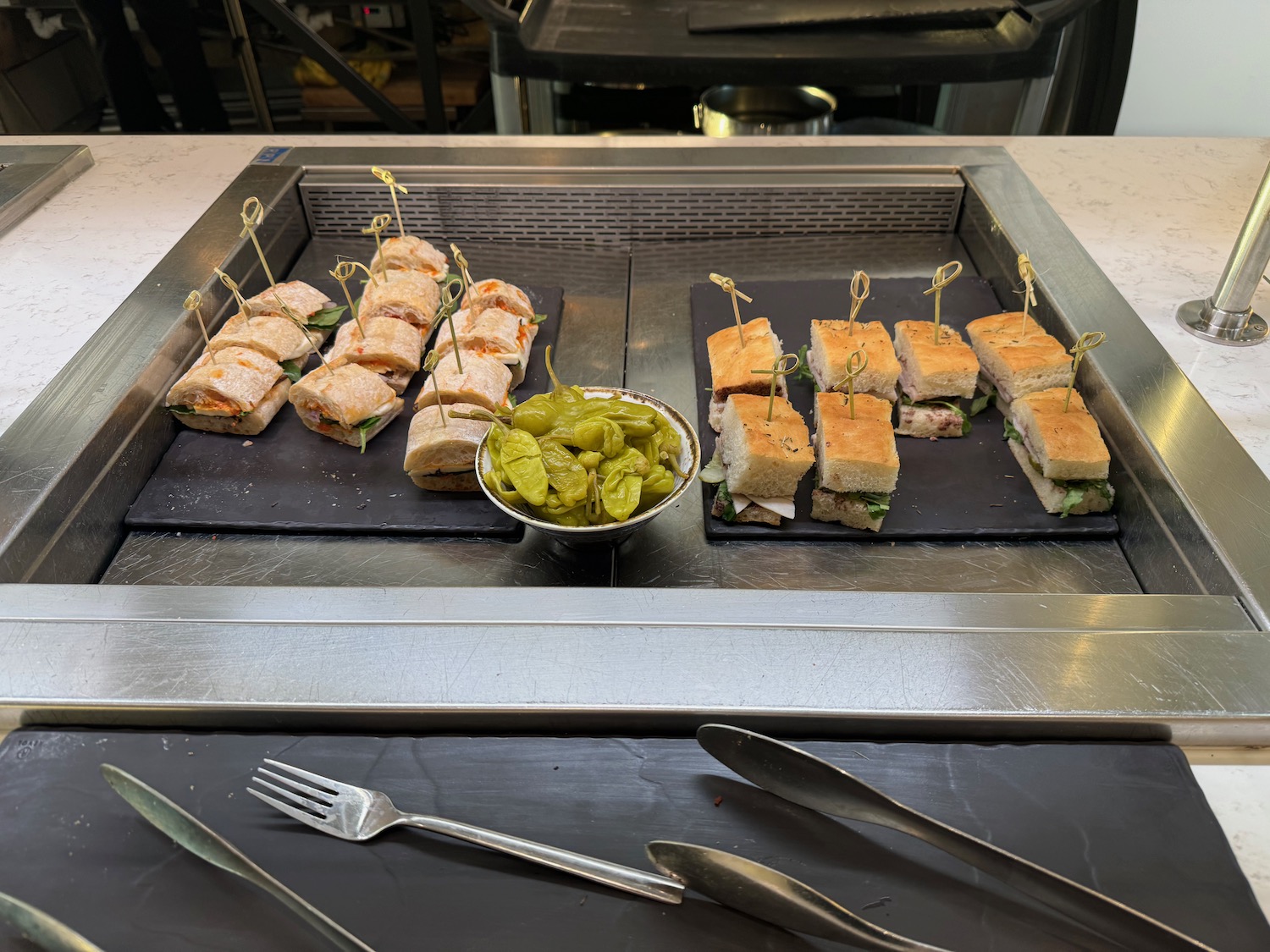 a tray of sandwiches and pickles