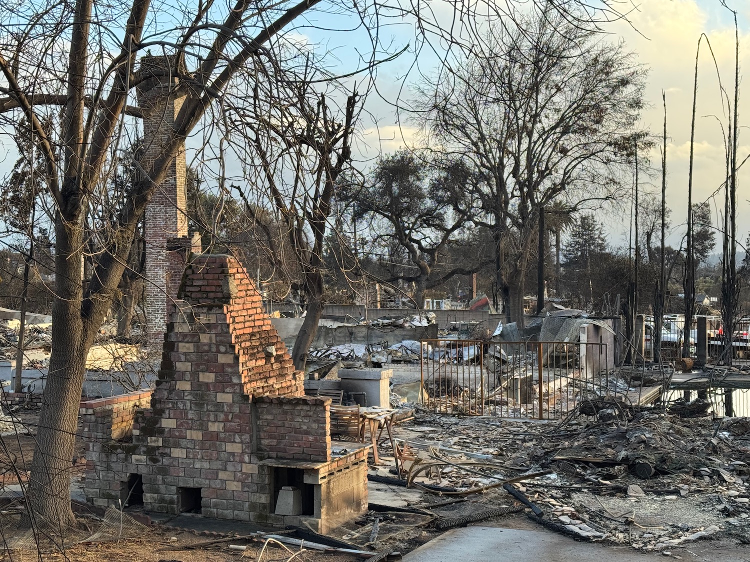 a brick fireplace and debris in a yard