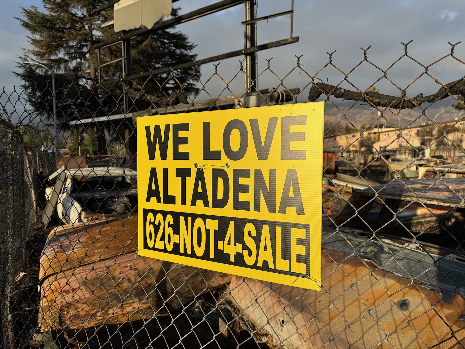 a yellow sign on a fence