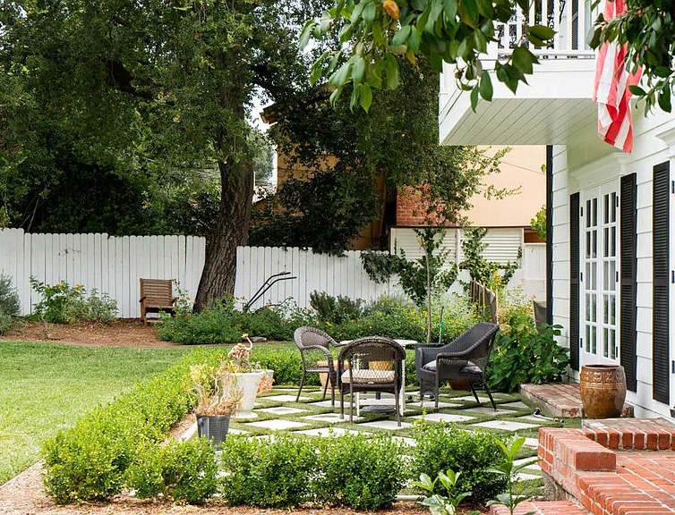 a patio with chairs and a white fence