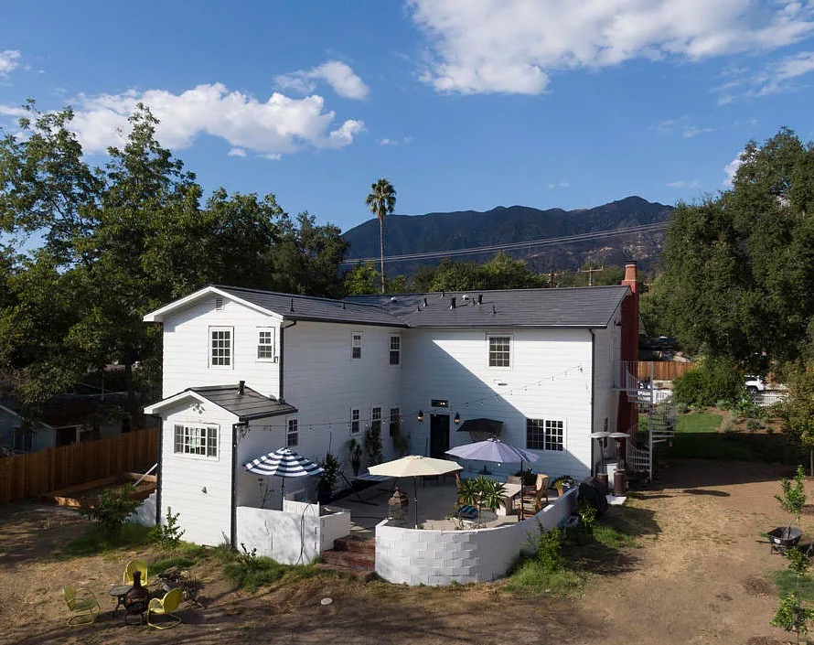 a white house with a fence and trees