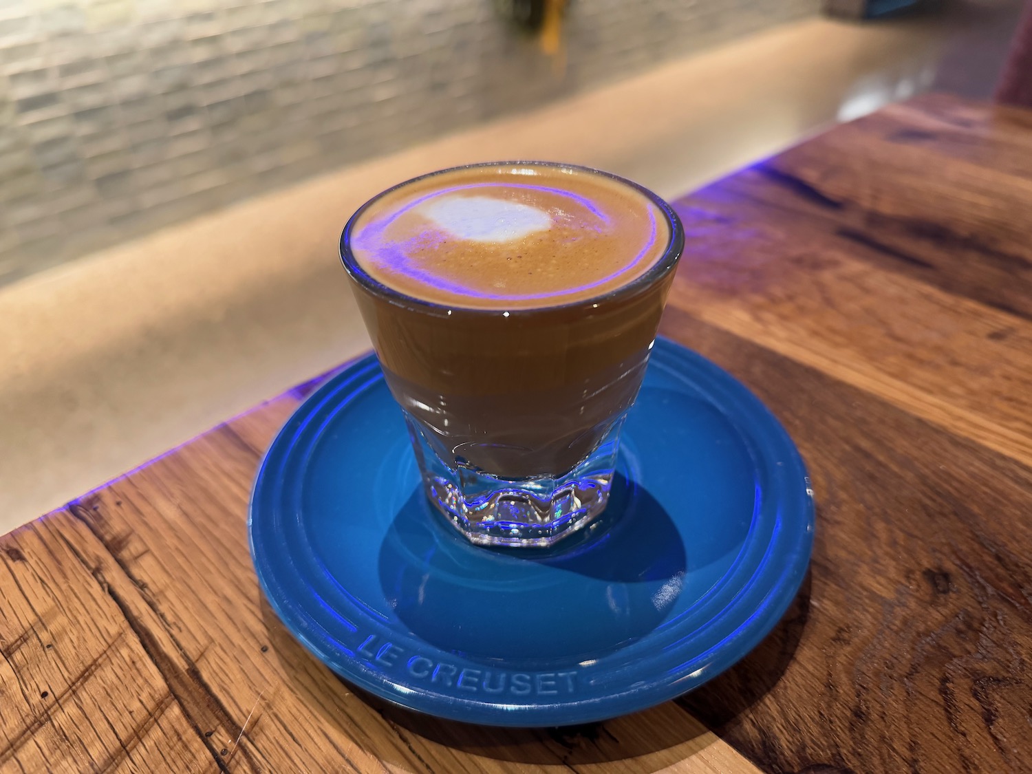 a glass of coffee on a blue plate