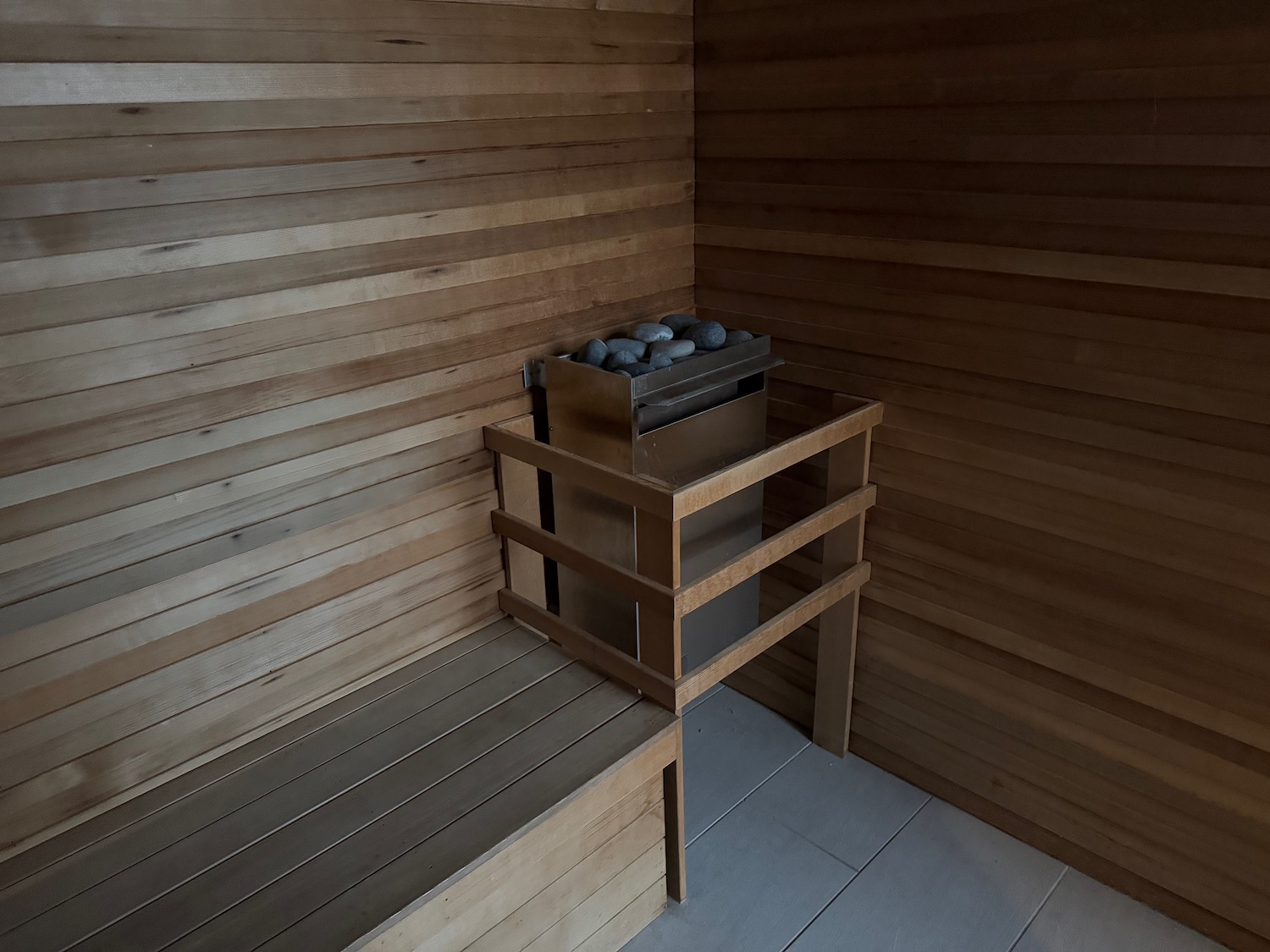 a wooden sauna with a hot tub and rocks