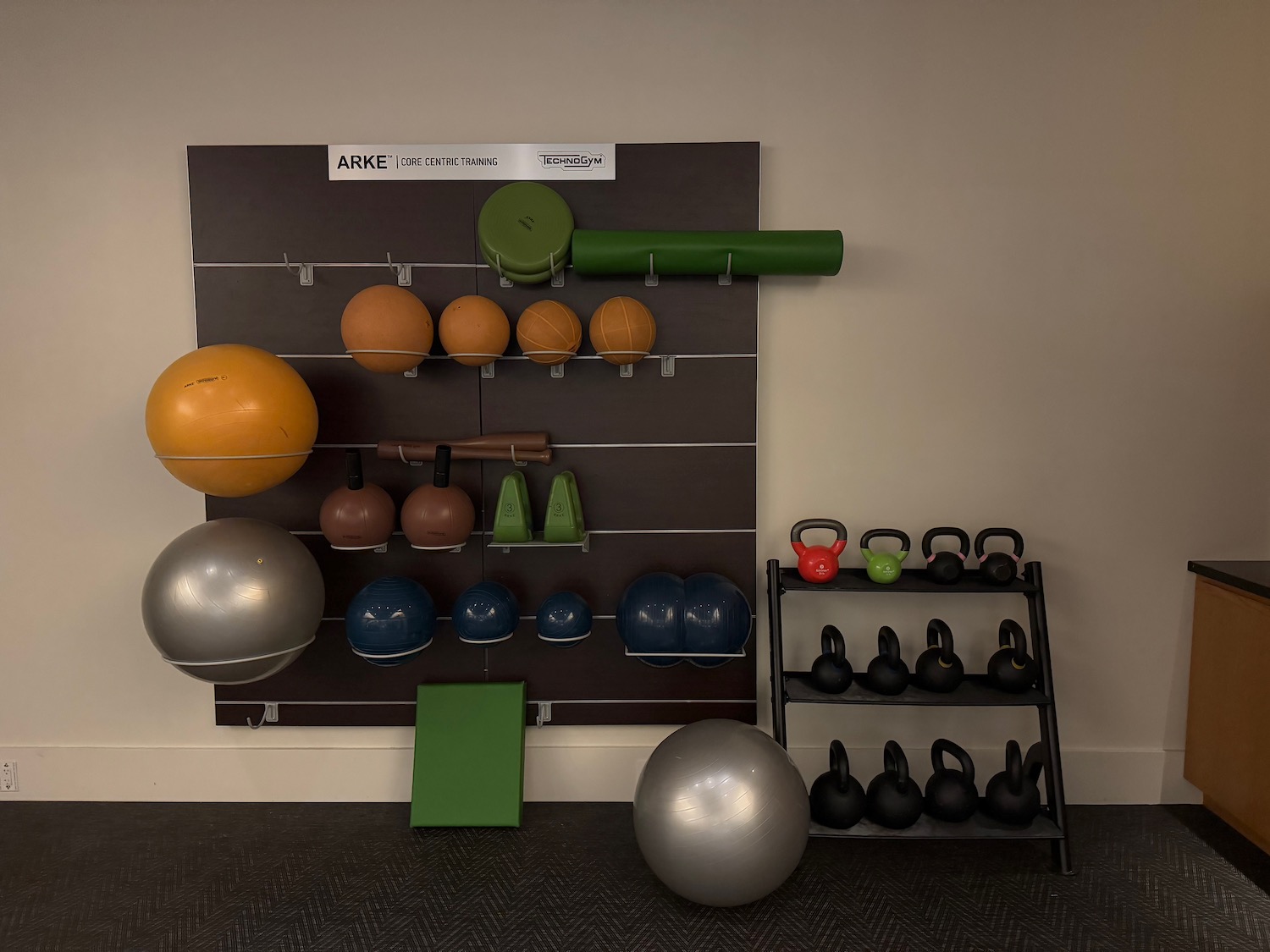 a wall with balls and kettlebells on it