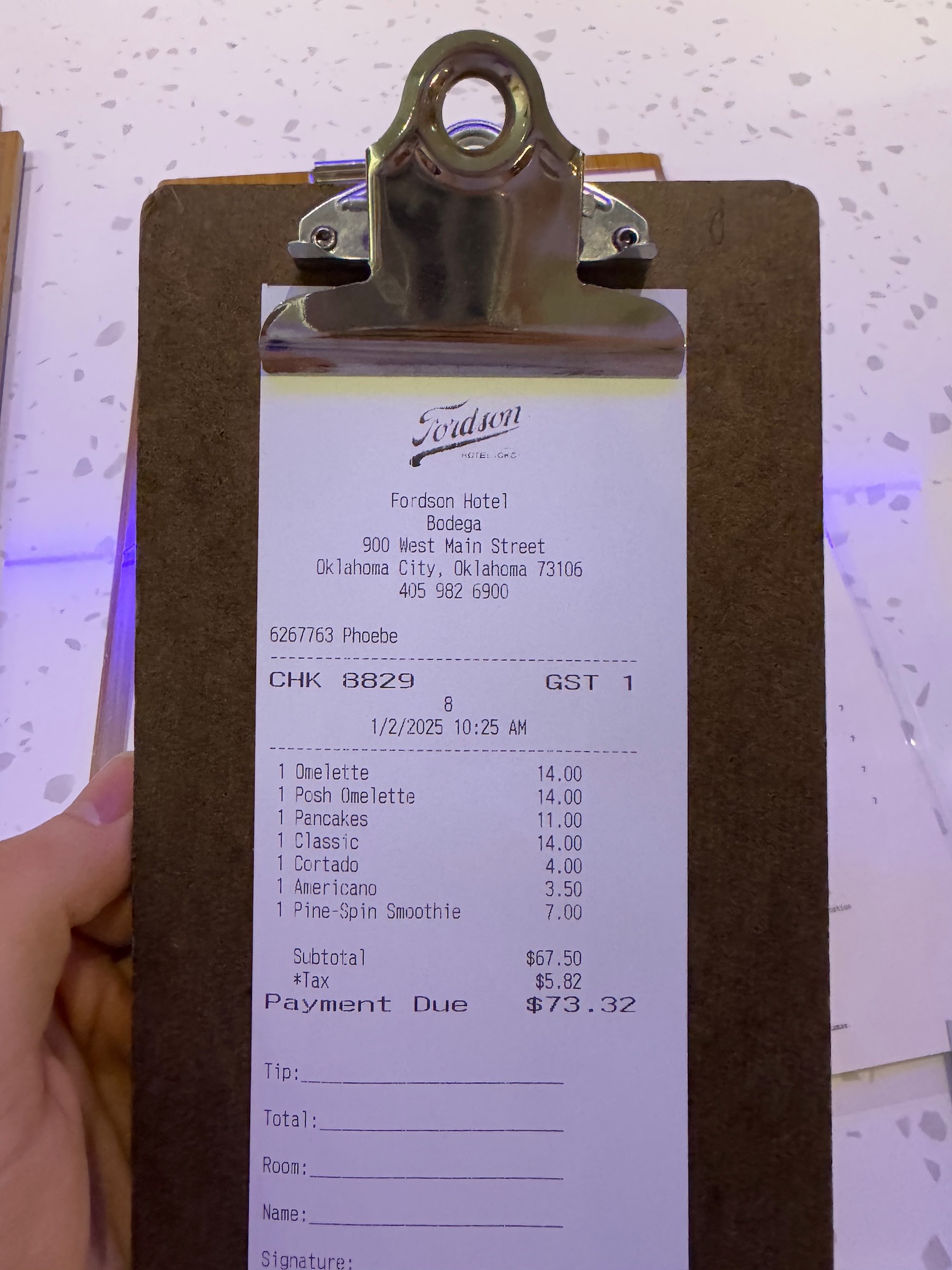 a hand holding a clipboard with a receipt