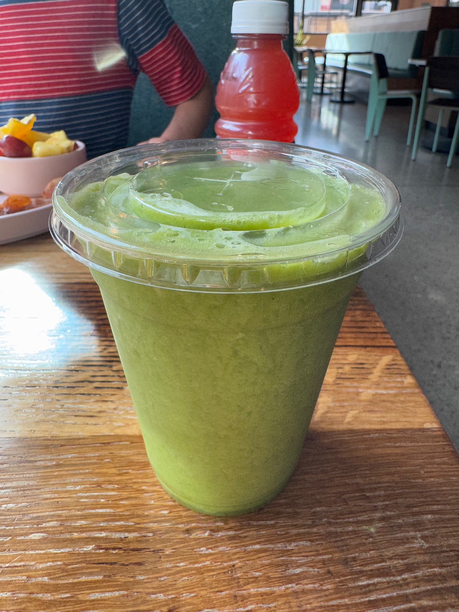 a green smoothie in a plastic cup