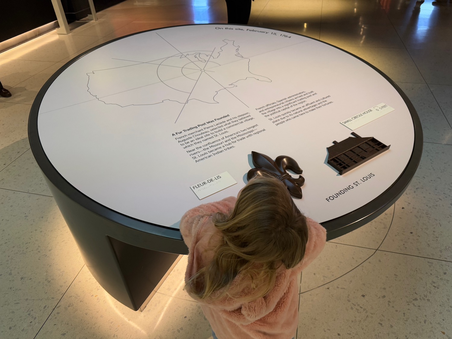 a girl looking at a table with a map