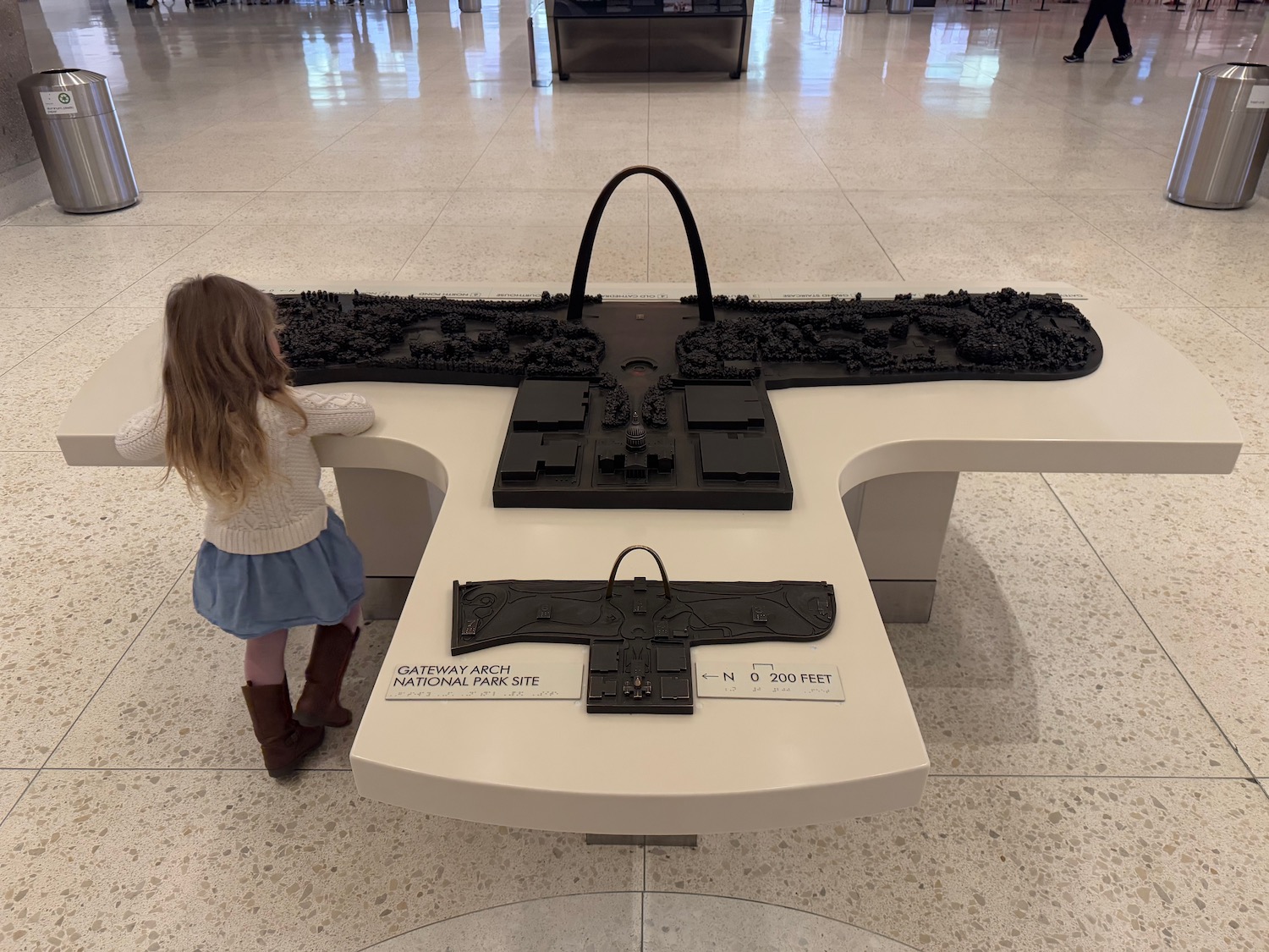 a girl standing next to a large black object