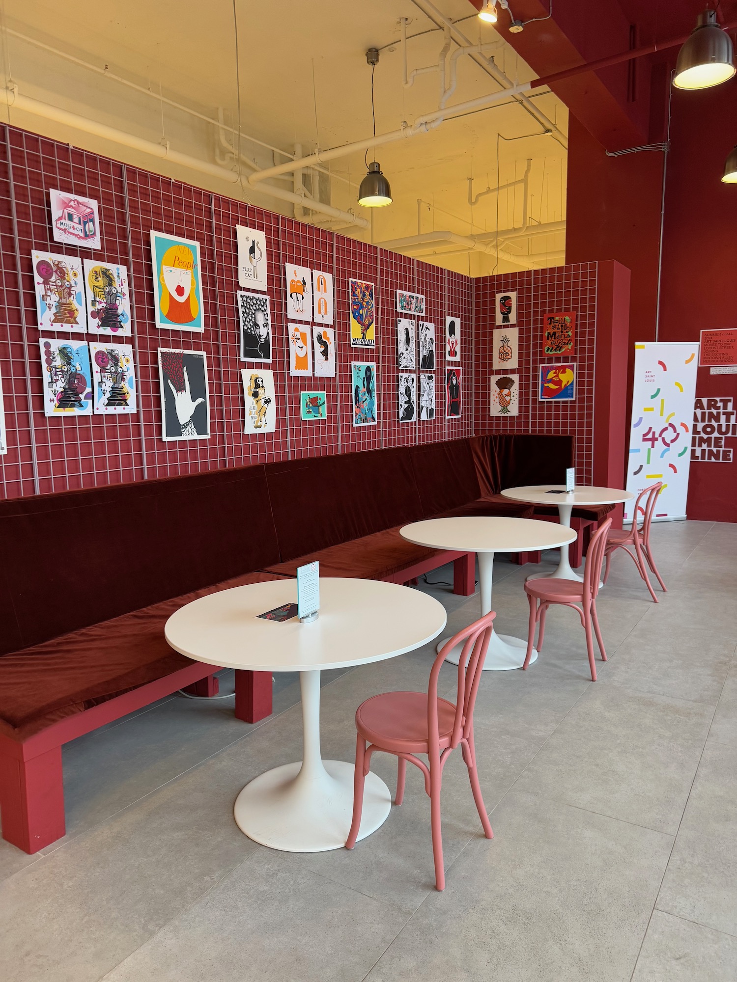 a room with red walls and white tables and chairs