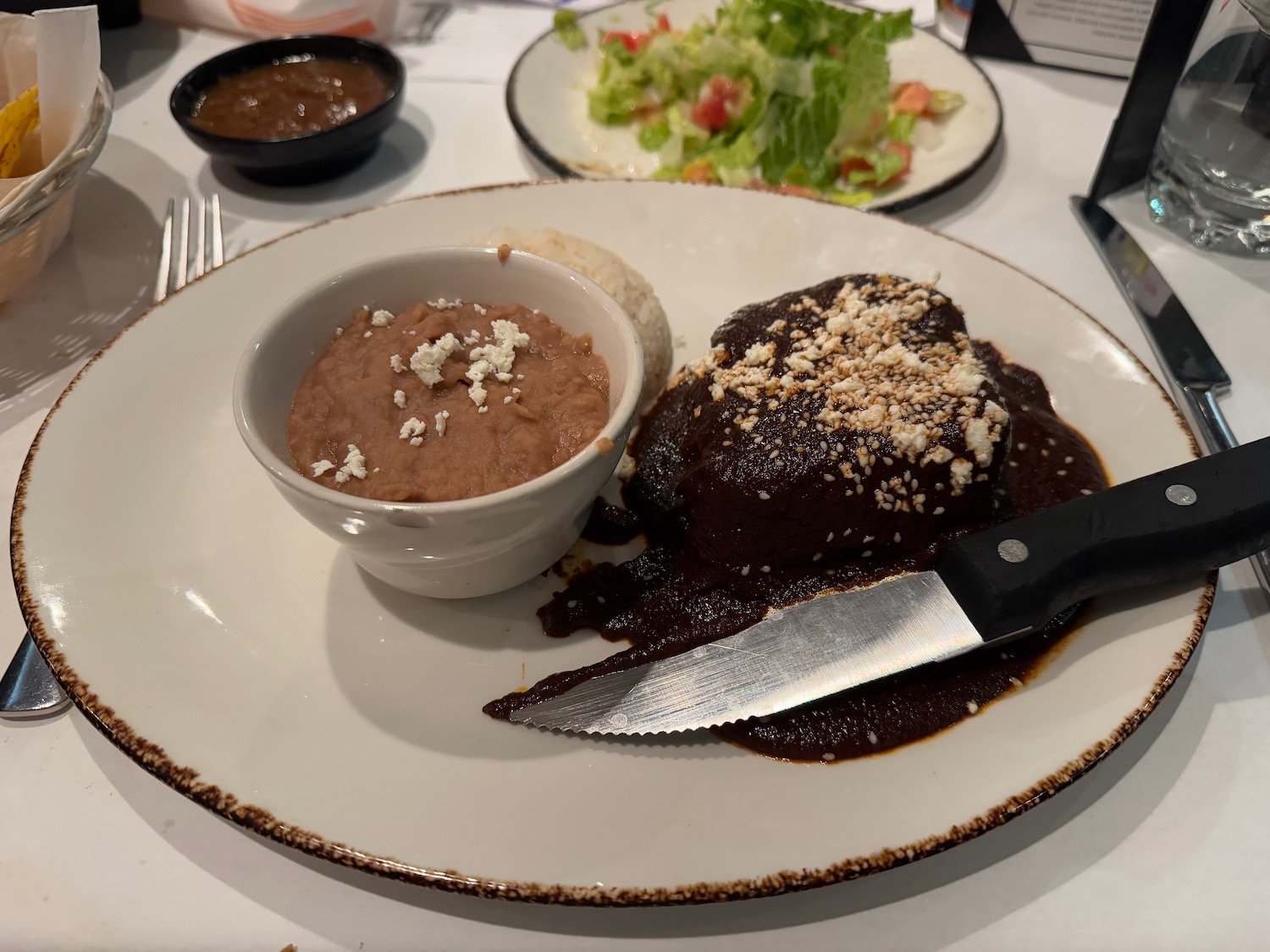 a plate of food with a knife and a bowl of food