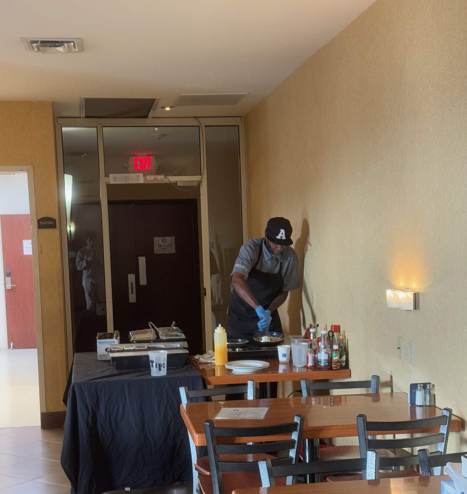 a man in a blue apron and gloves standing at a table